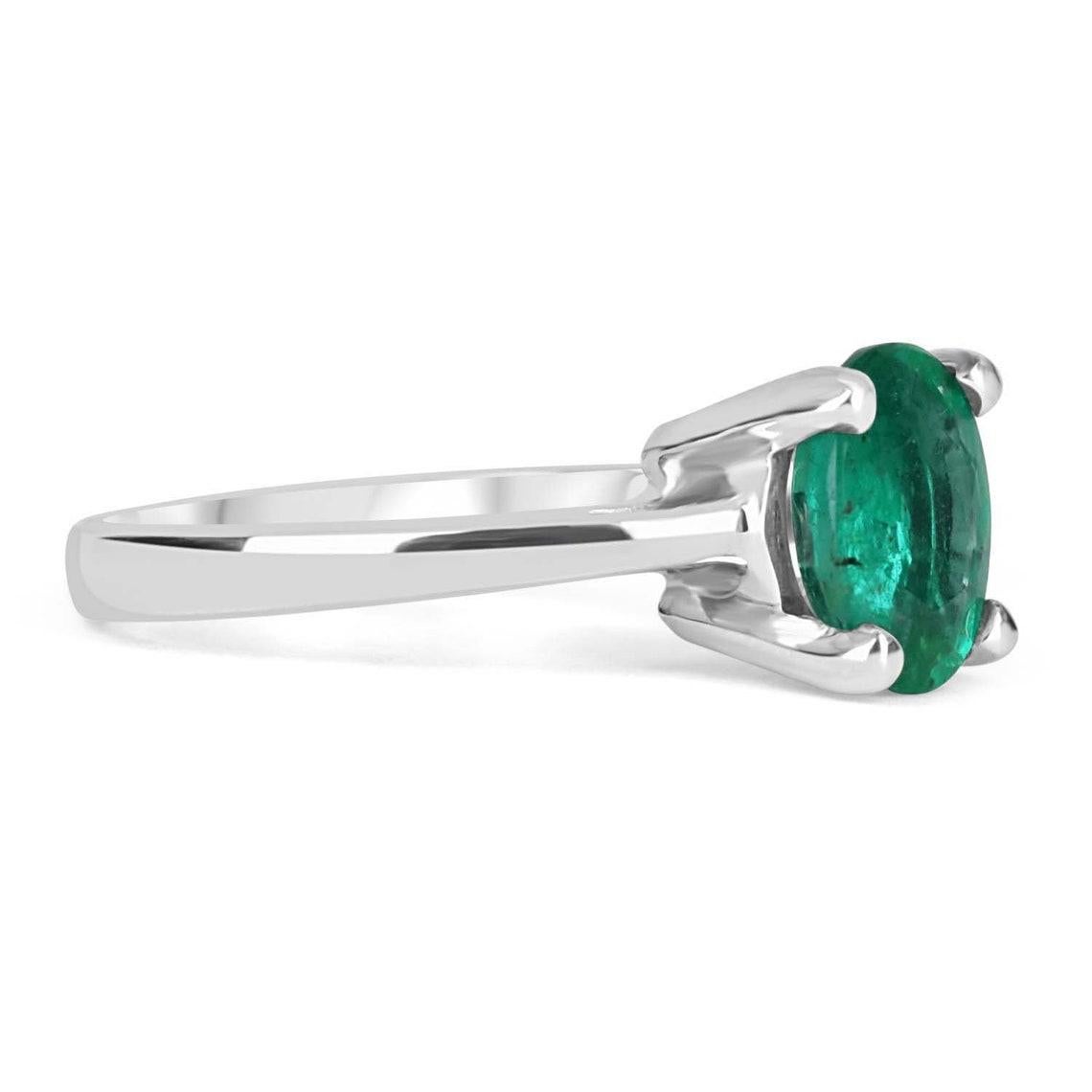 Displayed is a custom emerald solitaire oval-cut engagement/right-hand ring in 14K white gold. This gorgeous solitaire ring carries a 1.77-carat emerald in a four-prong setting. The emerald has very good clarity with minor flaws that are normal in