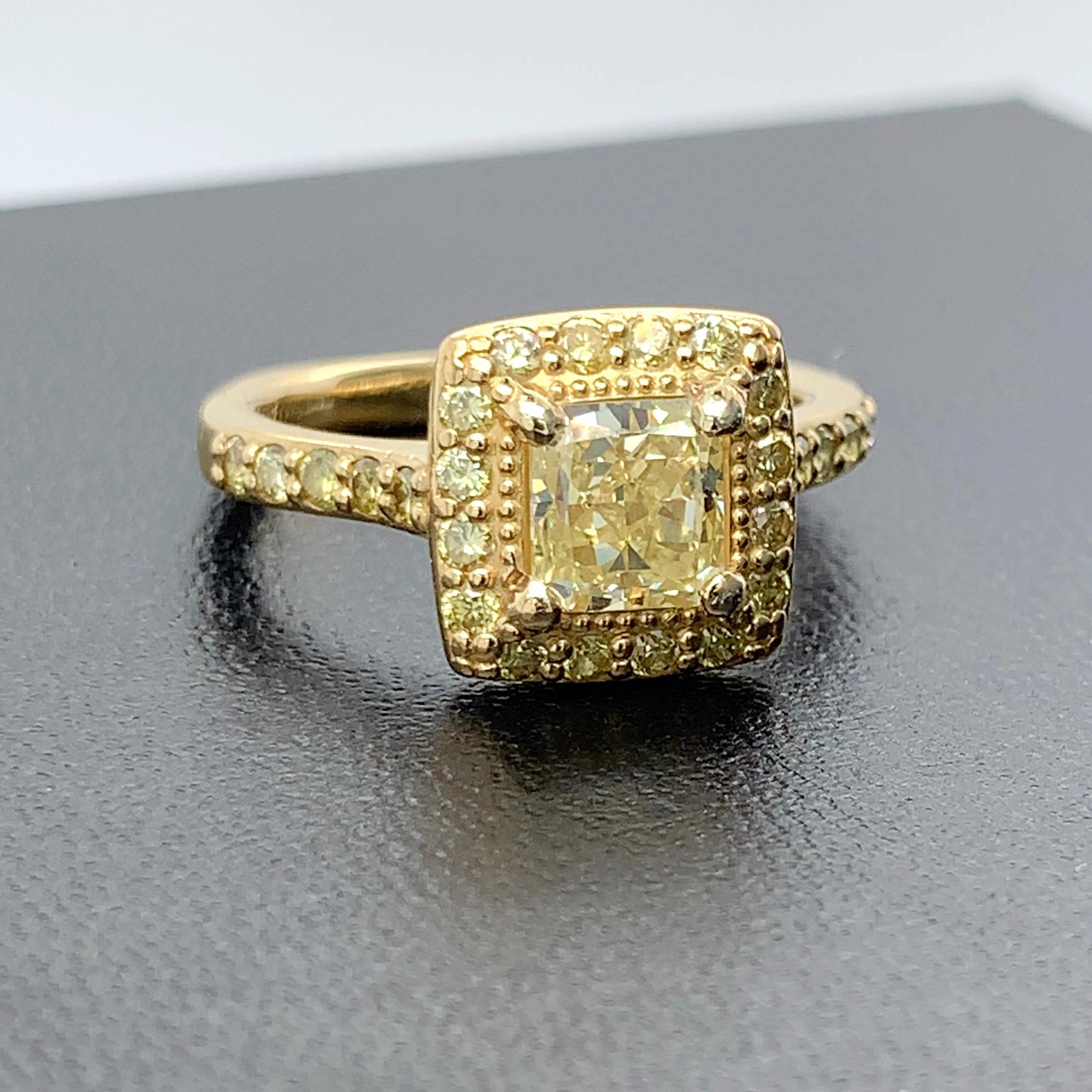 Own a piece of sunshine with this all fancy yellow diamond ring! Set in 18k yellow gold, the center fancy yellow diamond exudes radiance. The center diamond is 1.34 Ct, clarity VS2, fancy yellow color, even color distribution, and is accompanied by