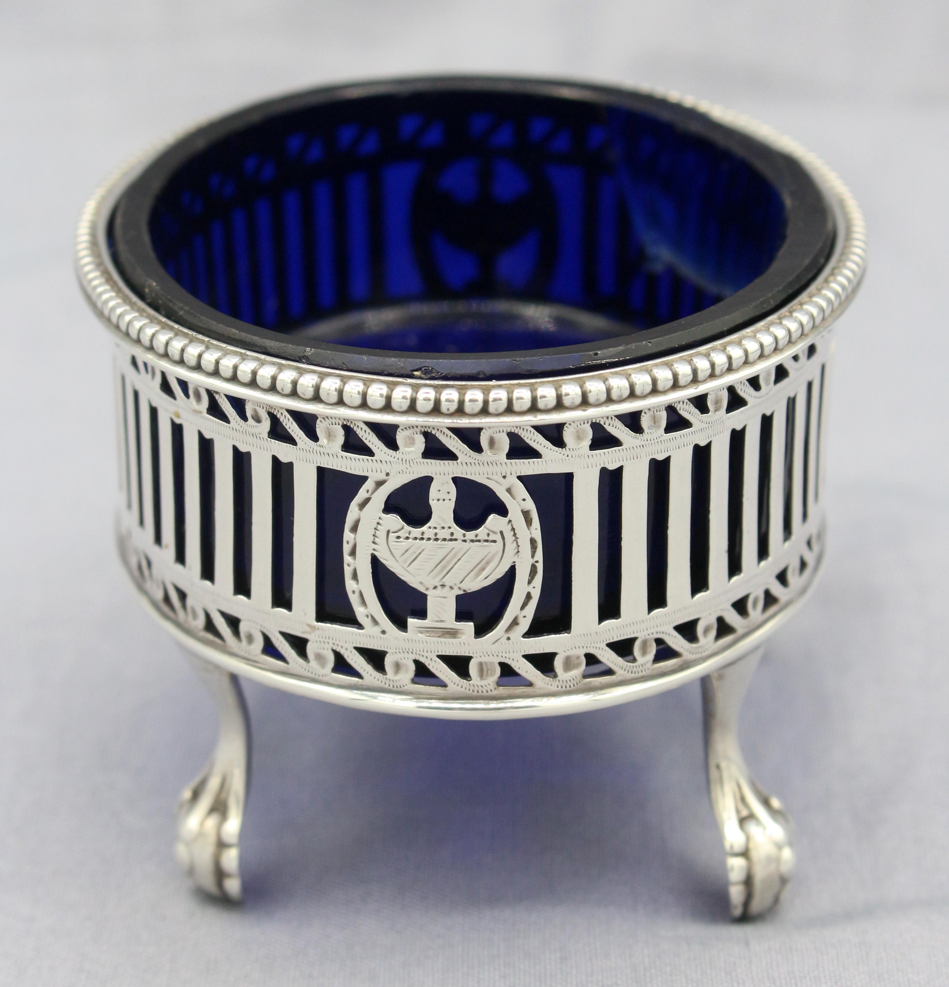 Sterling silver master salt by Hester Bateman, London, 1780. Star cut cobalt glass liner (old ground chip). Magnificent example raised on four ball & claw feet. The oval body has stunning bright cut pierced vitruvian scrolls & a beaded edge. The