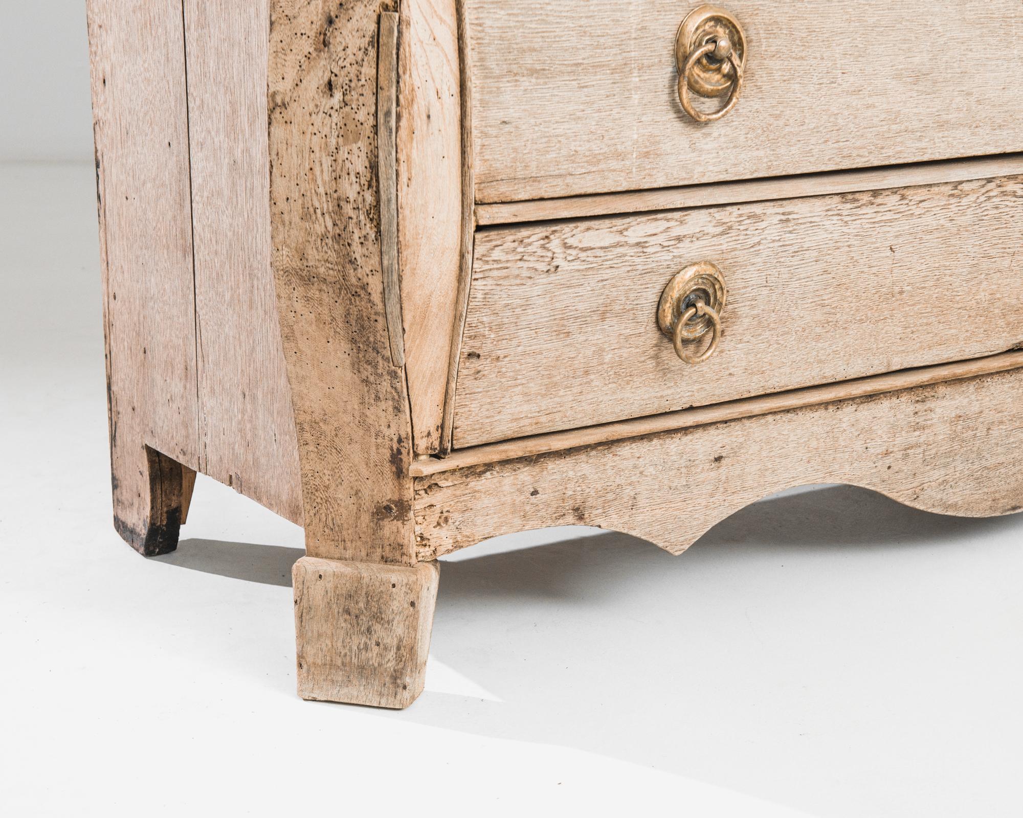 Embark on a journey to the opulent 1780s with this Dutch Bleached Oak Cabinet, a manifestation of Baroque elegance. The graceful scalloped apron at the bottom sets the stage for a piece that is nothing short of regal. Adorned in Baroque style, the
