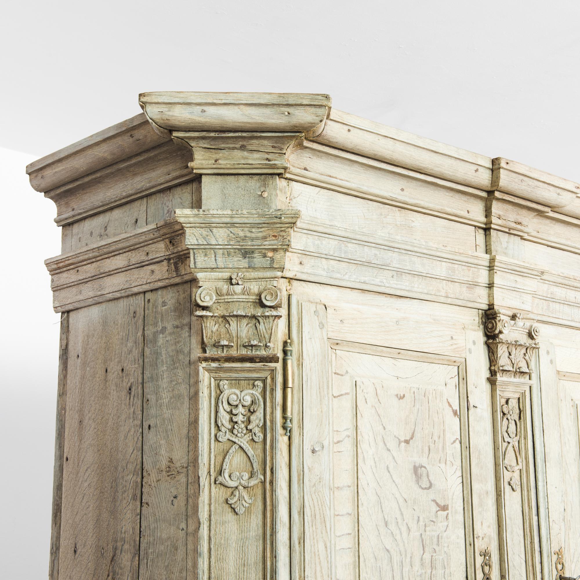 Une armoire en chêne blanchi de Belgique, produite vers 1780. En excellent état de fonctionnement, ce cabinet du XVIIIe siècle est une trouvaille extraordinaire. Presque aussi large que haute, cette pièce comporte deux niveaux d'armoires doubles