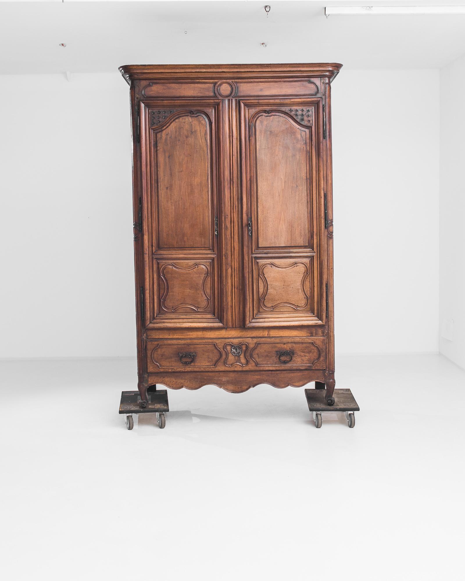 Elegant lines and a wealth of charming details gives this antique cabinet a perennial freshness. Made in France in the 1780s, the wood has retained its original finish — a rich auburn, with honeyed undertones and a silken polish. The fluid curves of