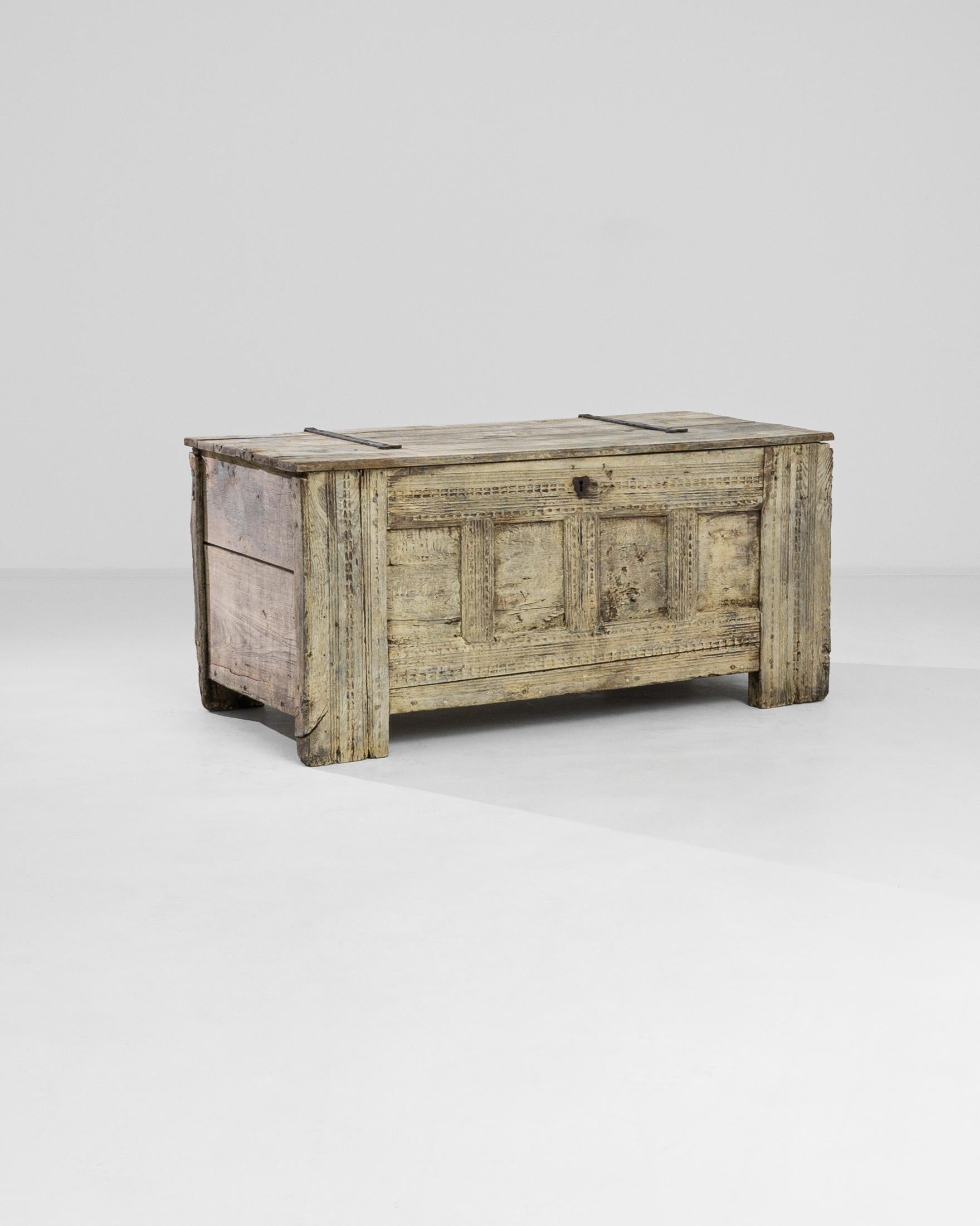 A beautiful bleached oak chest, from circa 1780 Germany. Refined in its old age, this rustic yet stylish chest offers a roomy storage compartment and a charming exterior. Sparse metal details and finely carved details ripple across its vanilla