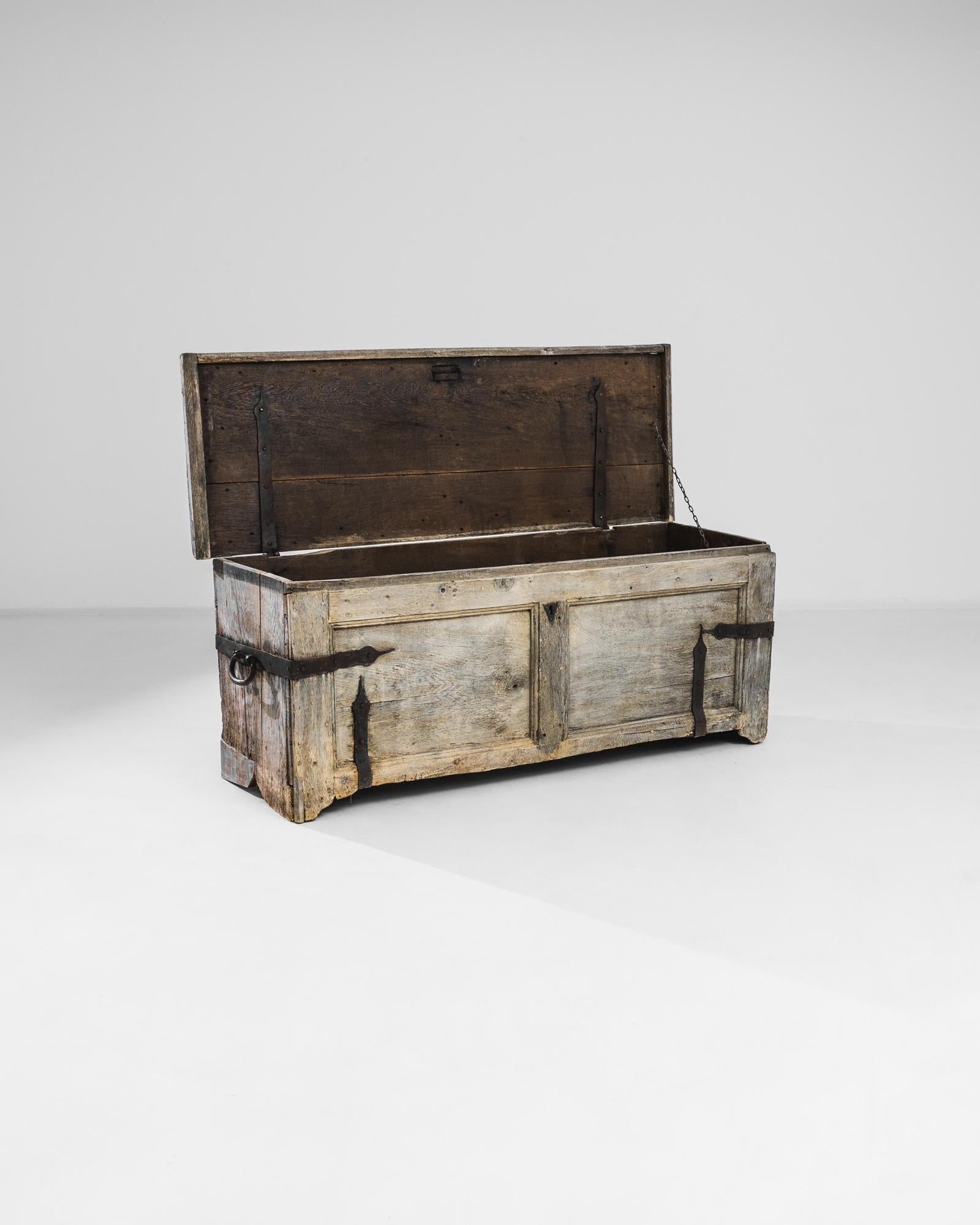 Entdecken Sie die mittelalterliche Eleganz dieser Truhe aus gebleichtem Eichenholz aus den 1780er Jahren, ein fesselndes Zeugnis für den unvergänglichen Charme antiker Handwerkskunst. Diese Truhe ist mit eisernen Akzenten verziert, die ihr einen