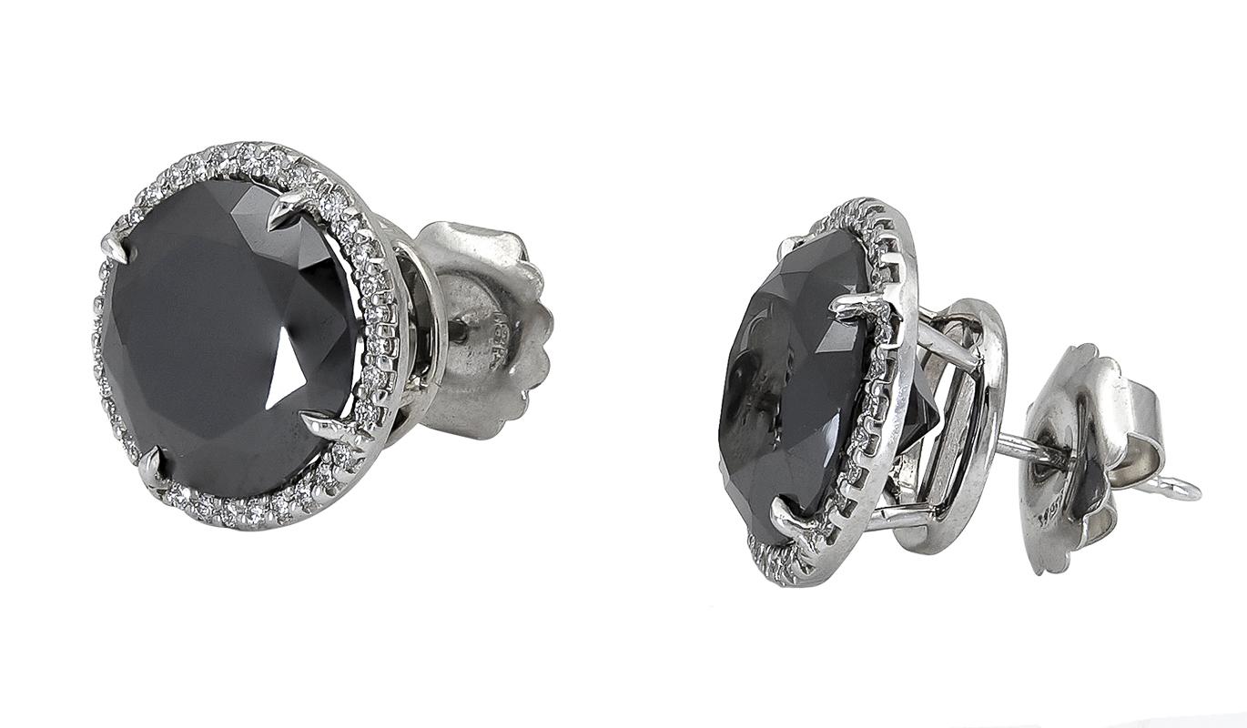 A versatile piece of jewelry that goes well with any outfit. Features two round black diamonds set in a brilliant diamond halo basket made in 18k white gold. 
Black diamonds weigh 17.88 carats total.
0.65 inches in diameter.