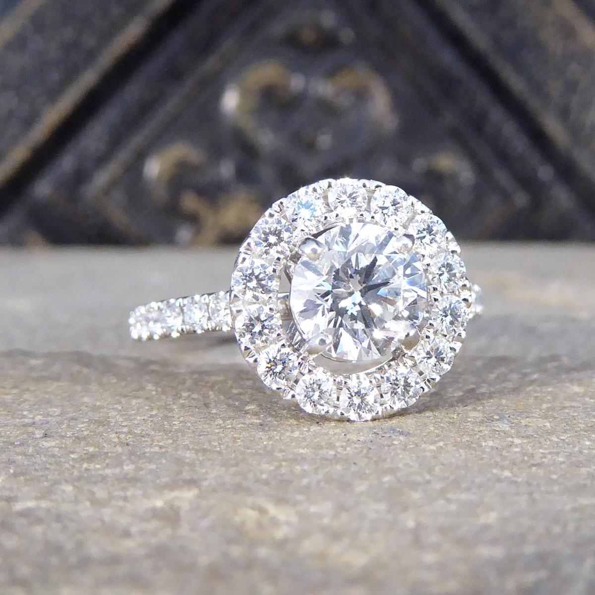 A beautiful and bright Diamond halo cluster ring set in platinum. This exquisite piece features a stunning 1.04ct re-homed stone at its centre, cut to perfection in a Brilliant Cut style, giving it the second hand price appeal with a brand new