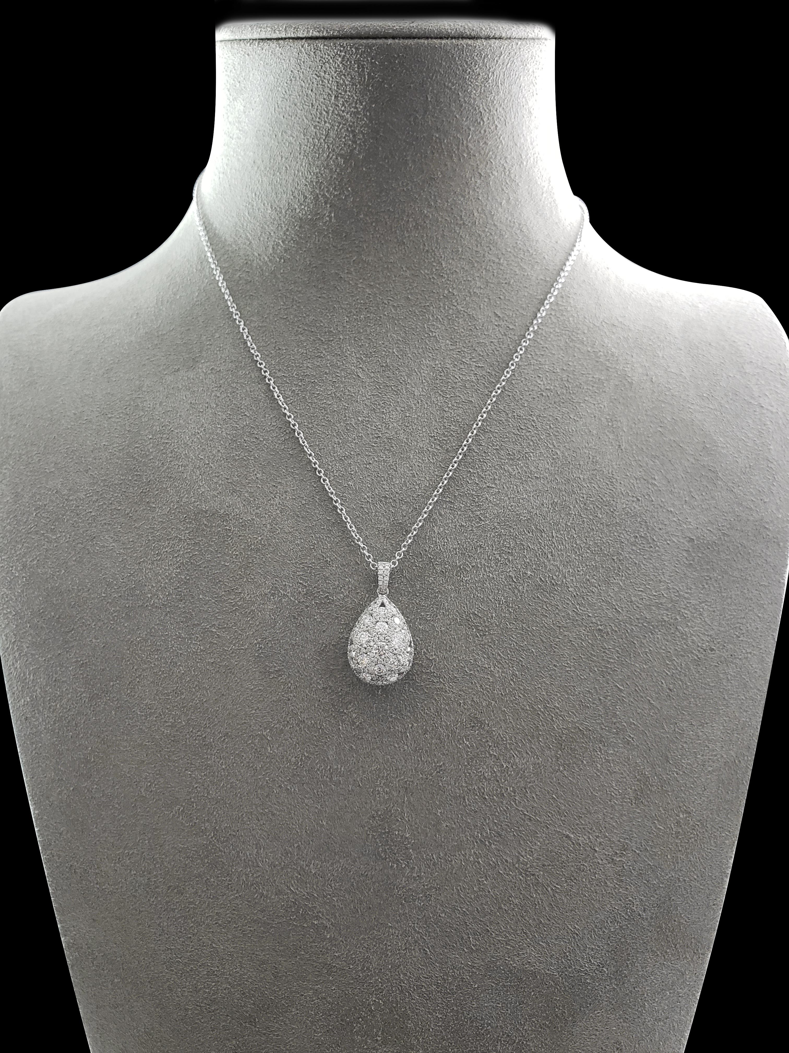 This is an intricately designed and lustrous pendant necklace showcasing a cluster of diamonds elegantly set in a rounded 18k white gold teardrop-shaped pendant. Each diamond is very brilliant and is perfectly matched. Suspended on a diamond