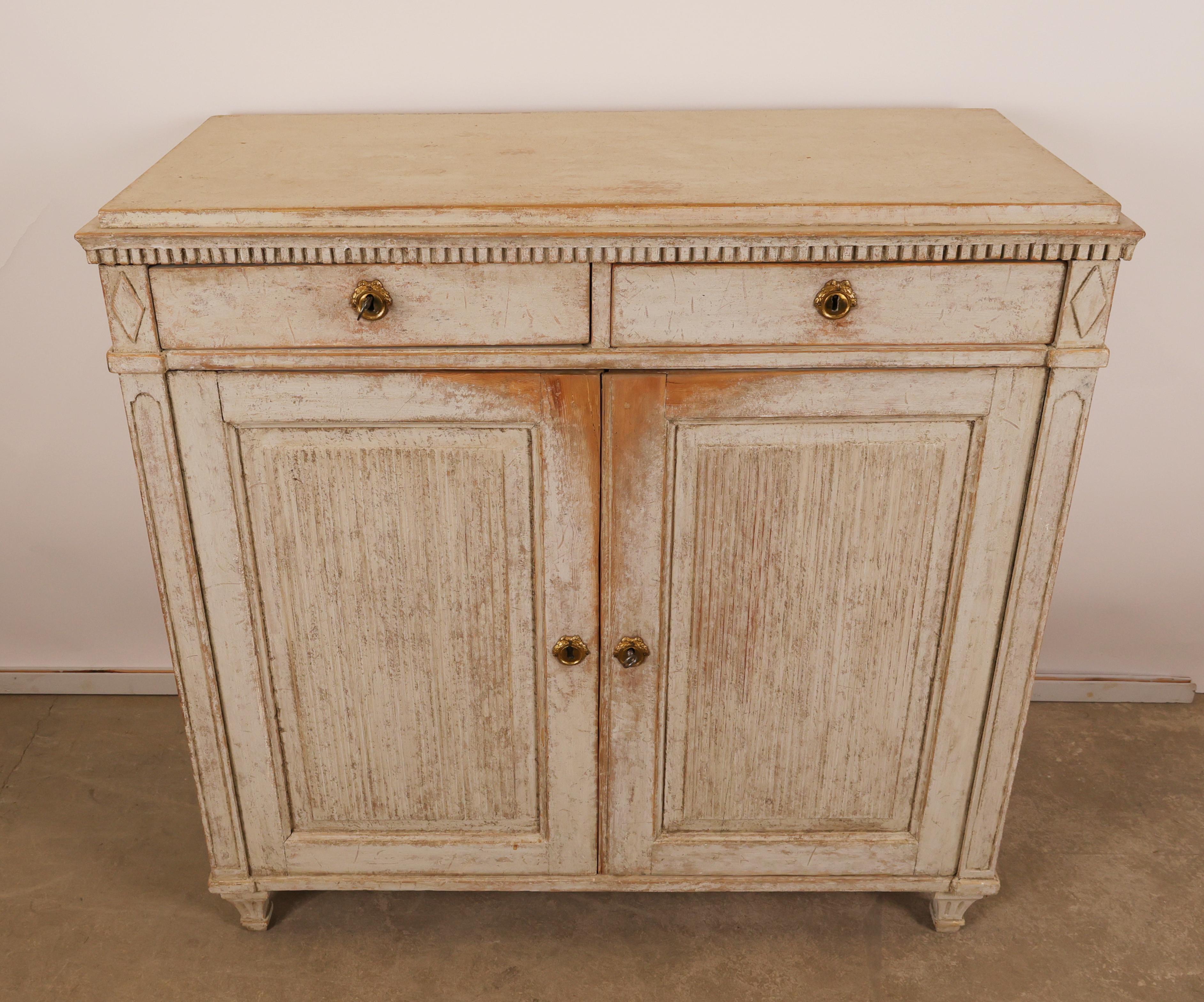 Pièce gustavienne de Stockholm, vers 1790-1800. Les deux tiroirs sont ornés d'un motif décoratif en dents de scie. Les portes sont ornées de miroirs cannelés et l'intérieur du meuble comporte deux étagères. Les pieds sont typiquement gustaviens,