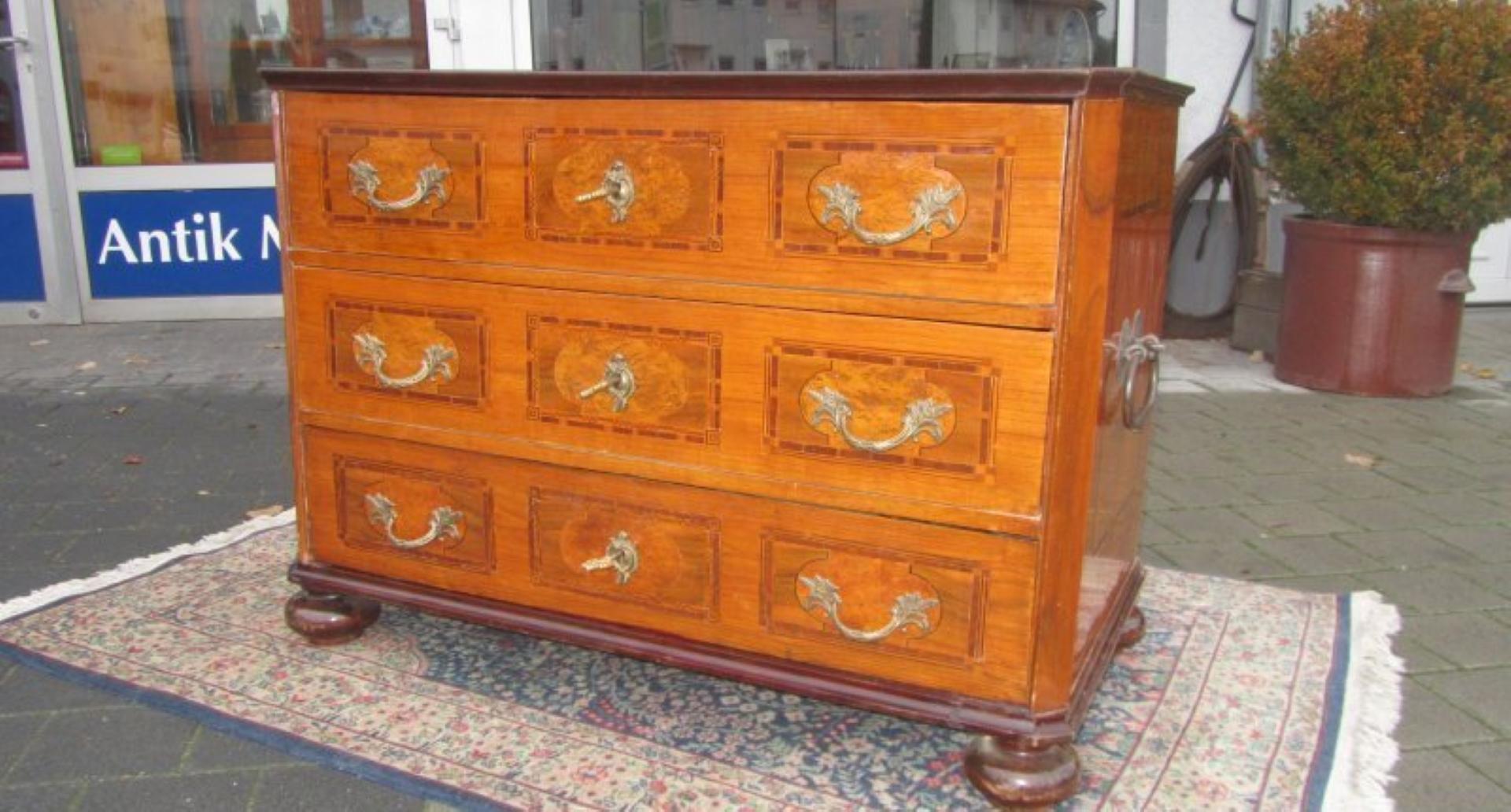 Luxurious antique Baroque commode or chest of drawers made of oakwood veneer as well as birch wood and mahogany inlay works. An elegant masterpiece from the 1790s with original brass handles, original locks and keys. Perfect restored condition with