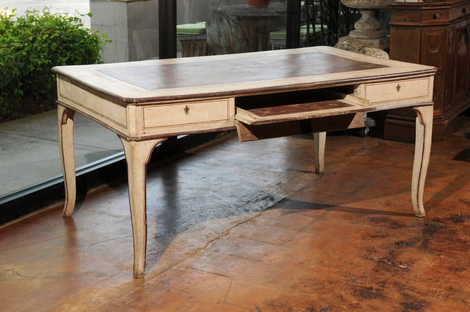 An Italian painted wood desk from the late 18th century with hidden drawers, faux leather top and cabriole legs. This Italian writing table features an exquisite rectangular top with rounded edges, adorned in its center with a brown faux leather