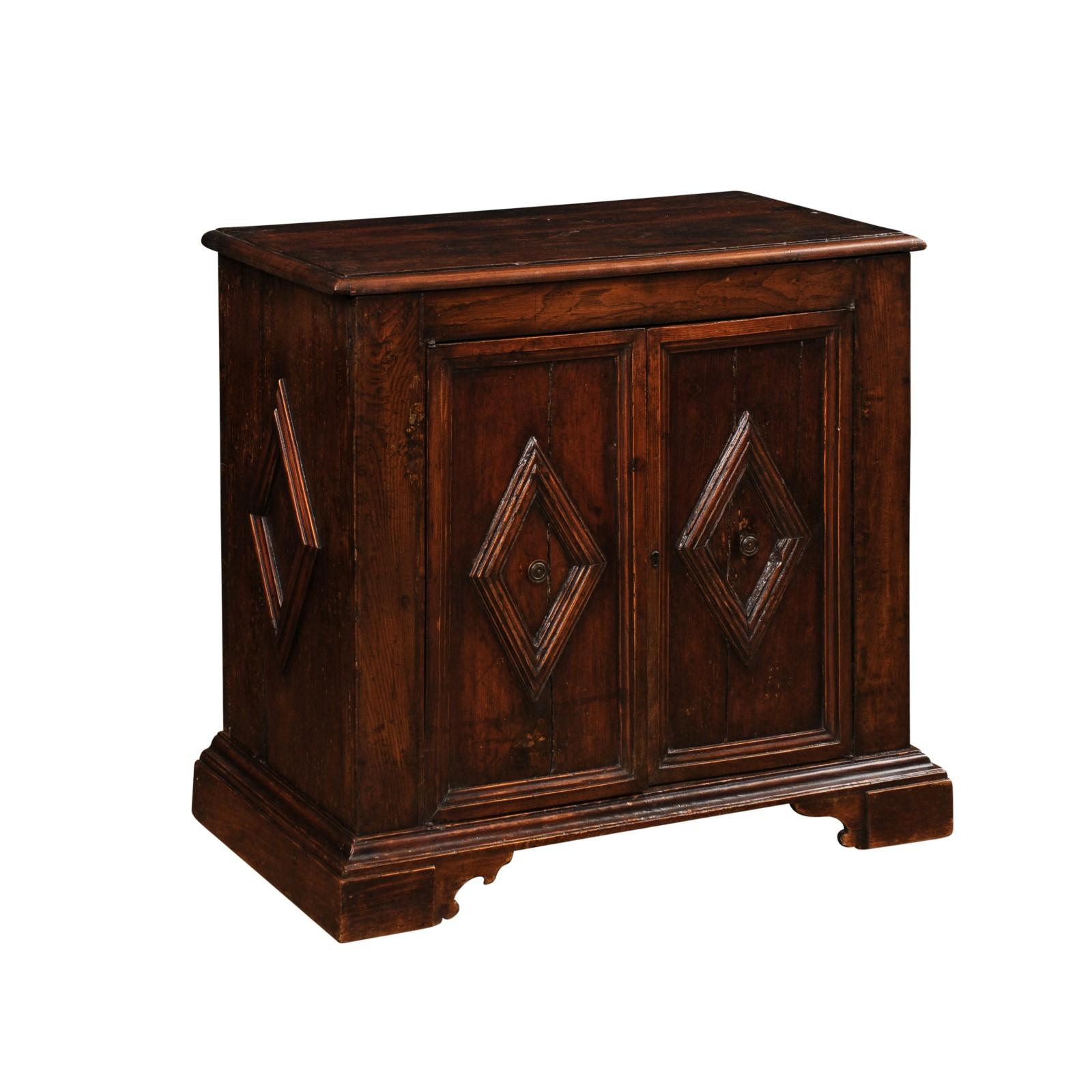 An Italian walnut buffet from circa 1790 with two doors and carved diamond motifs. Embrace the timeless beauty and rich heritage of this Italian walnut buffet from circa 1790, a masterpiece of craftsmanship and design from the late 18th century.