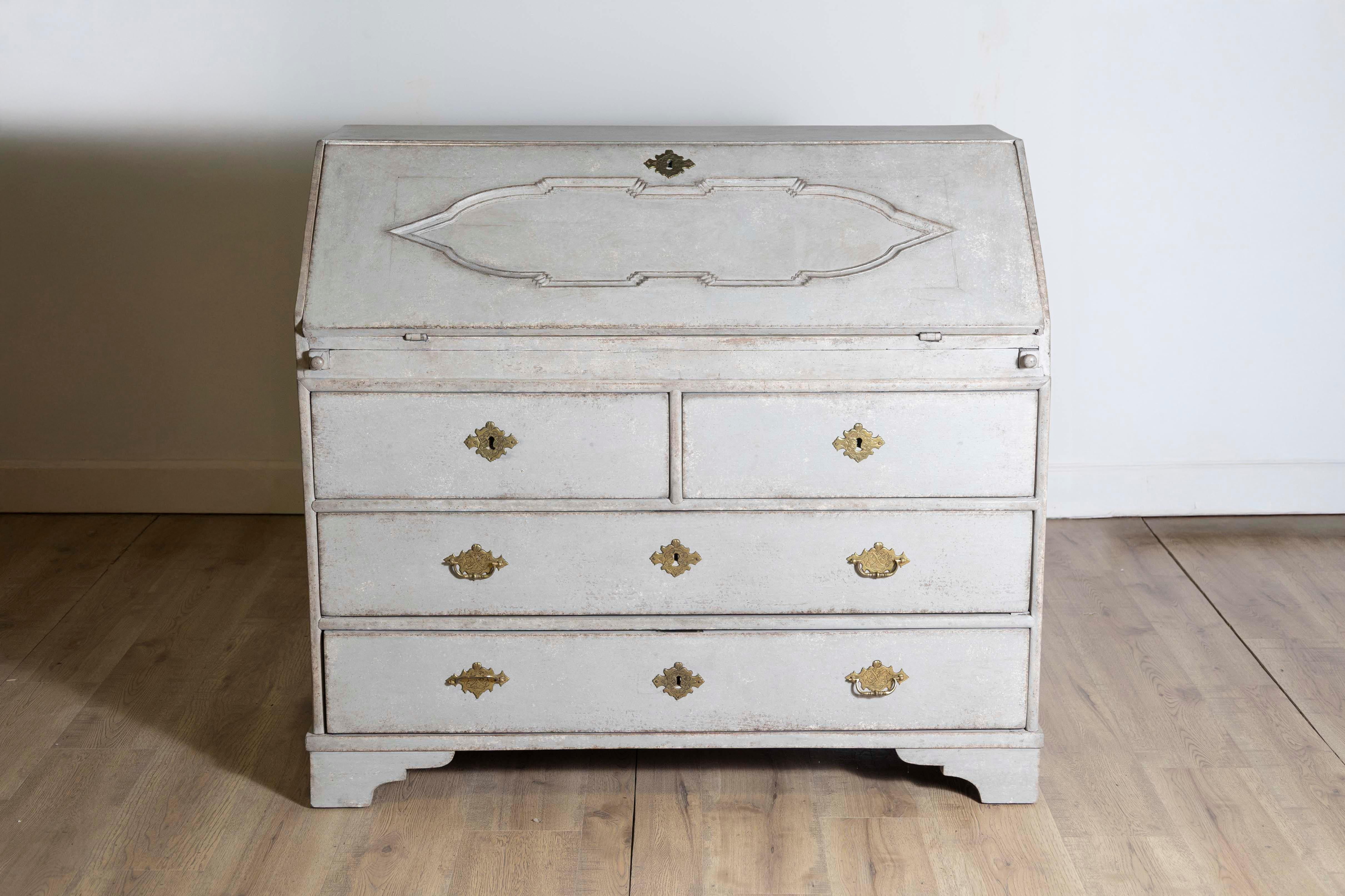 A Scandinavian light/medium grey painted slant-front desk from circa 1790 with carved panel and four drawers. Emanating the quiet elegance of Scandinavian design, this circa 1790 light/medium grey painted slant-front desk is a remarkable fusion of