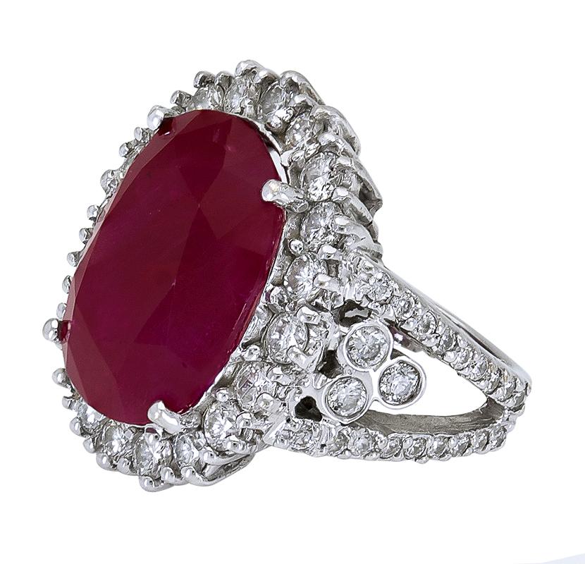 Elle est ornée d'un rubis rouge vibrant de 17,94 carats à taille coussin, rehaussé d'un halo de diamants ronds de taille brillant. Elle est montée sur une monture chic à tige fendue, sertie d'autres diamants. Fabriqué en or blanc 18 carats.
Le rubis