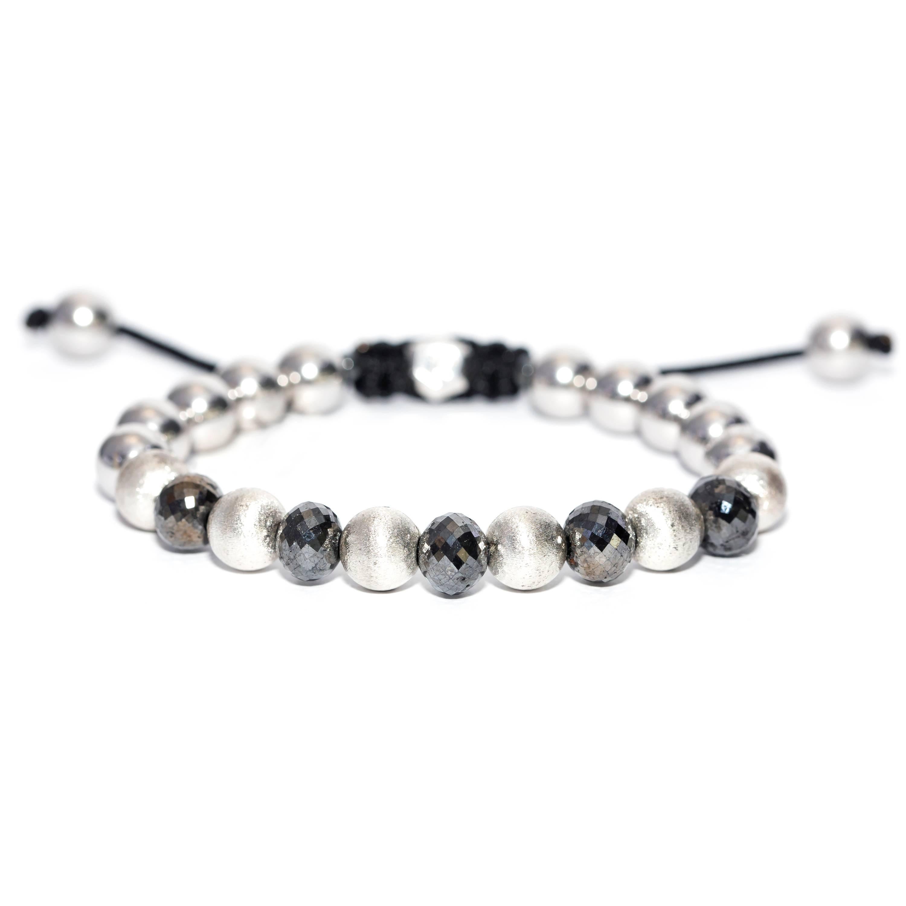 Made to order, this 17.95 Carat Black Diamond Stainless Steel Magnetite and Silver Macrame beaded bracelet features 6 satin beads and 10 Stainless Steel beads and 5 faceted black diamond beads with a Silver Hexagon Tresor Paris Logo. Size will fit