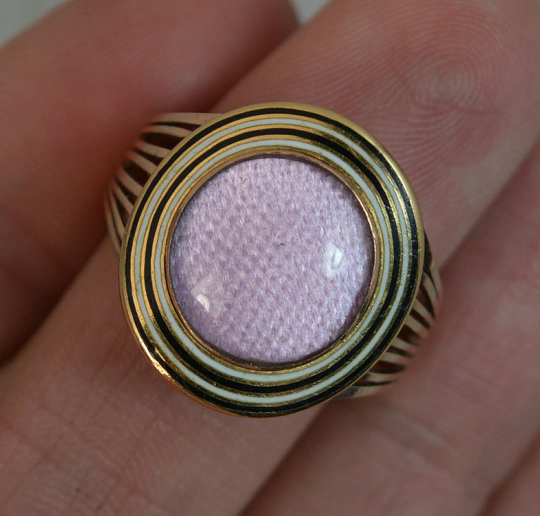 A Georgian period mourning cluster ring.
18 carat rose gold example.
A large circular head. Attractive lilac purple colour to centre. Surrounded by two rows of white and black enamelling,
18mm head. Fine split pierced shoulders. Easy wearing
