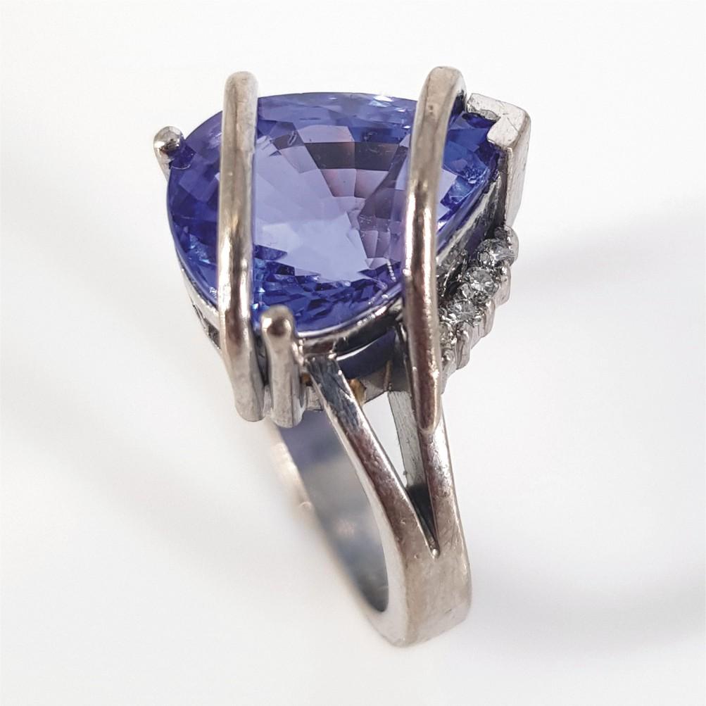 This Beautifully crafted piece is set in 17carat white gold weighing 7 grams.
This Ring features 1 Pear shaped Tanzanite weighing an estimate of 3.8carats, and is surrounded by 4 RBC Diamonds (GH vssi) weighing 0.4carat in total. The ring size is