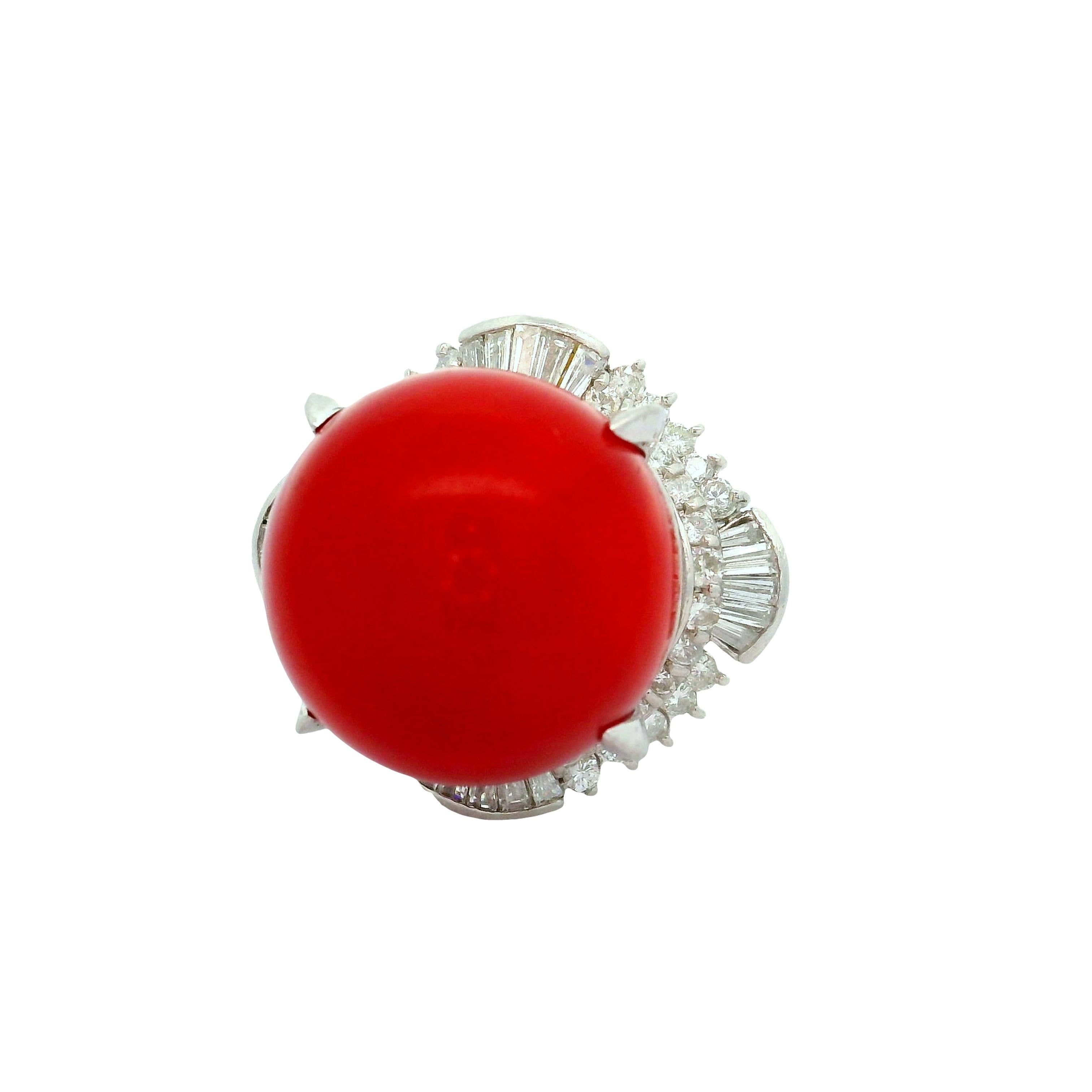 A striking coral, measuring 17mm, commands attention in this contemporary cocktail ring. The coral displays a vivid red color, bold and eye-catching. Encircling the coral are mixed-cut white diamonds, totaling 1.55 carats, adding brilliance and