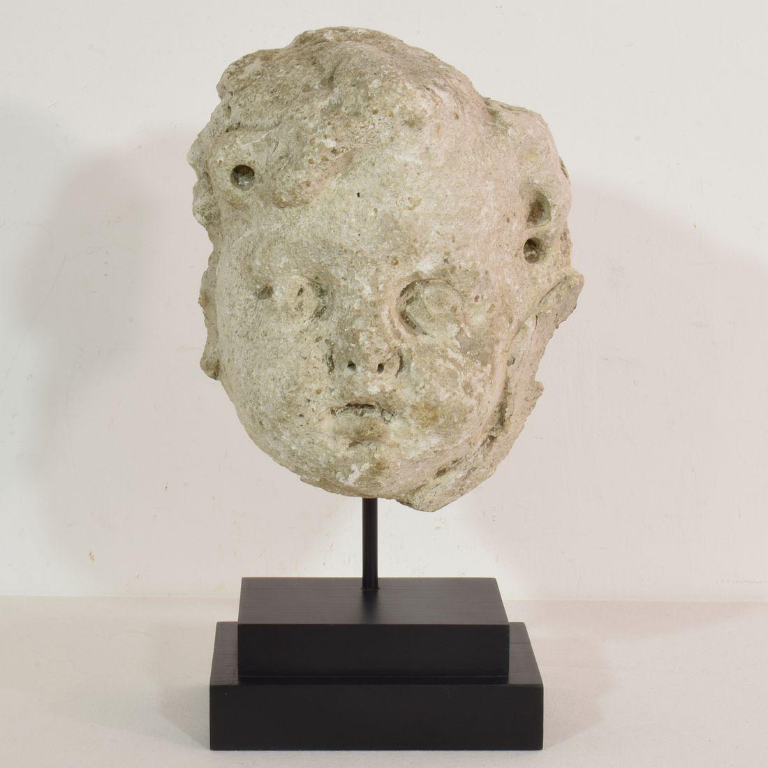 Amazing piece. Stucco/stone paste fragment of an angel head that once adorned a facade. Extremely weathered but still beautiful expression. Placed on a wooden base. France circa 1650/1750. Weathered and losses.
Measurement below is inclusive the