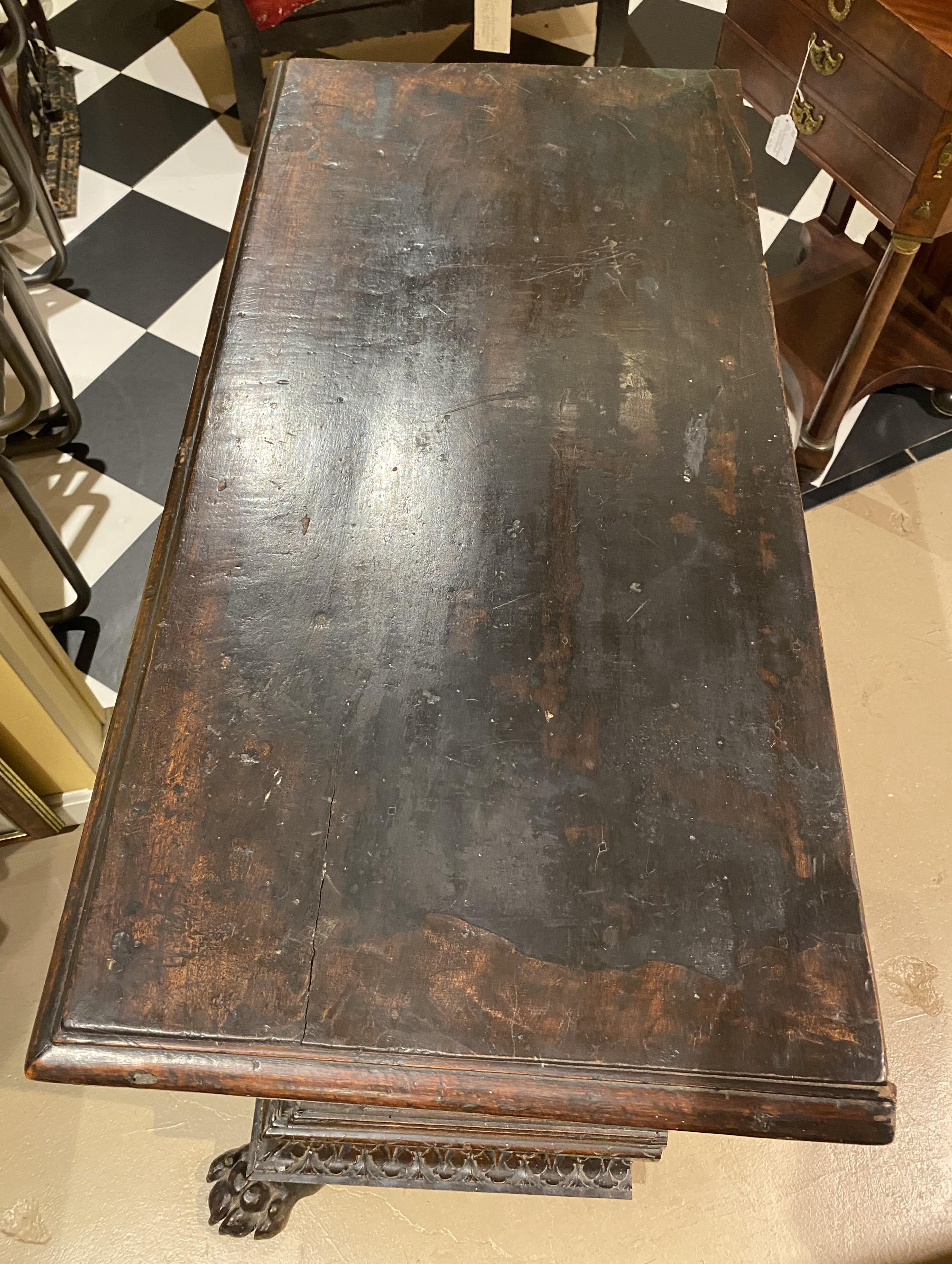 A nice example of a heavily carved wooden three drawer chest or cabinet in its original finish, most likely walnut, with figural carved drawer fronts, carved face escutcheons, foliate carved corners and borders, and adorned with front paw feet. The