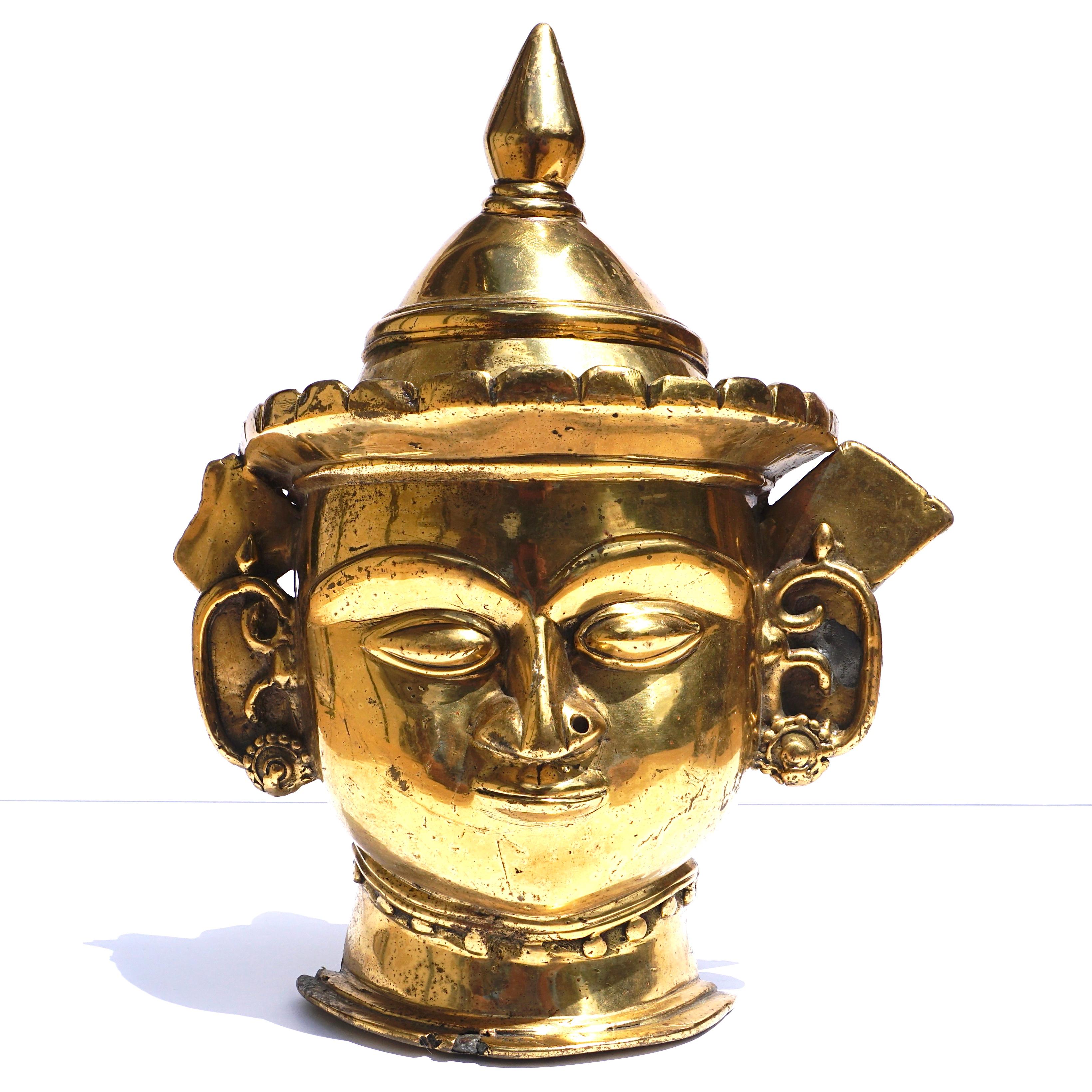 A Indian Mukhalingam Mukha face Lingum mask. A decorative gilt bronze Shiva facial representation of a Hindu God for phalic Lingums. A rare ritual artistic artifact. 

Dimensions: 12 x 10 x 3.5 inches

Condition: Very good with wear and restorations