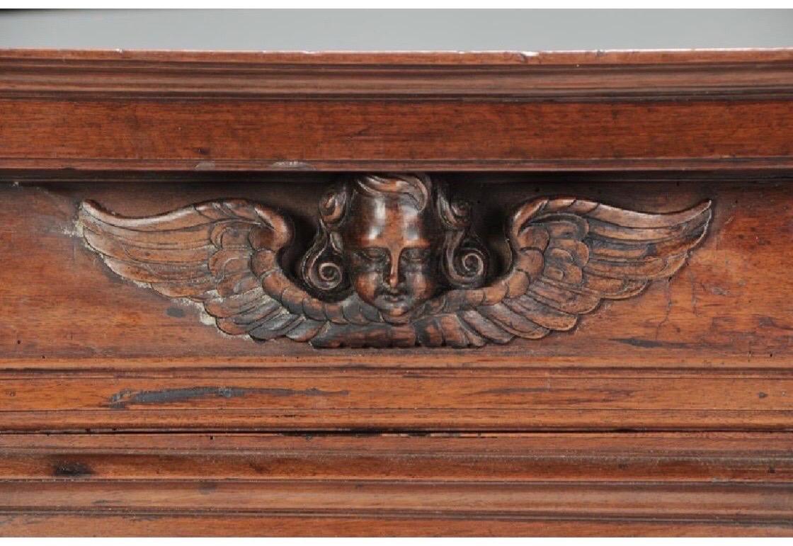 Italian baroque walnut cupboard from the late 17th-early 18th century. Wonderful carvings including leaves, rosettes, and winged angel carved motifs. Two piece cabinet consisting of two dovetailed drawers separating 4 paneled doors. 


 