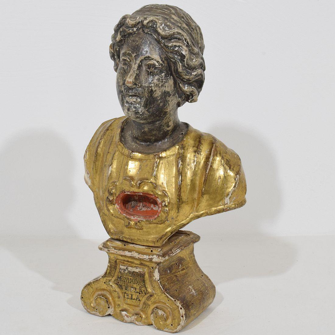 Spectacular and very decorative piece. Carved wooden reliquary bust representing a Saint figure. Beautiful traces of its original silver and gilding. Weathered, small losses and without the relics. Despite of its high age in a very good