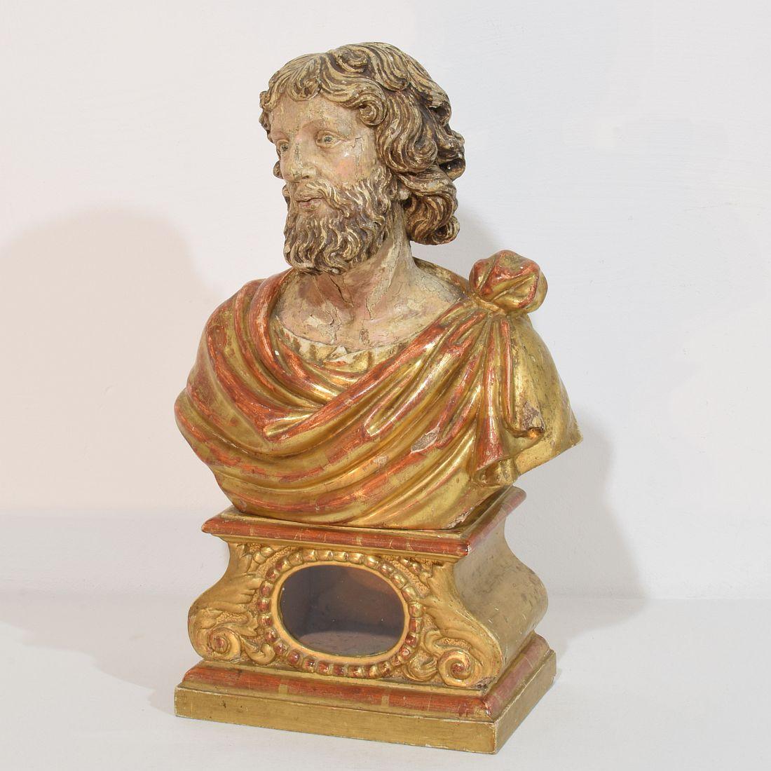 Pièce spectaculaire et très décorative. Grand buste reliquaire en bois sculpté représentant un saint. Magnifique peinture et dorure altérées par le temps. Petites pertes / réparations anciennes et sans les reliques. Italie vers 1650-1750. 
De