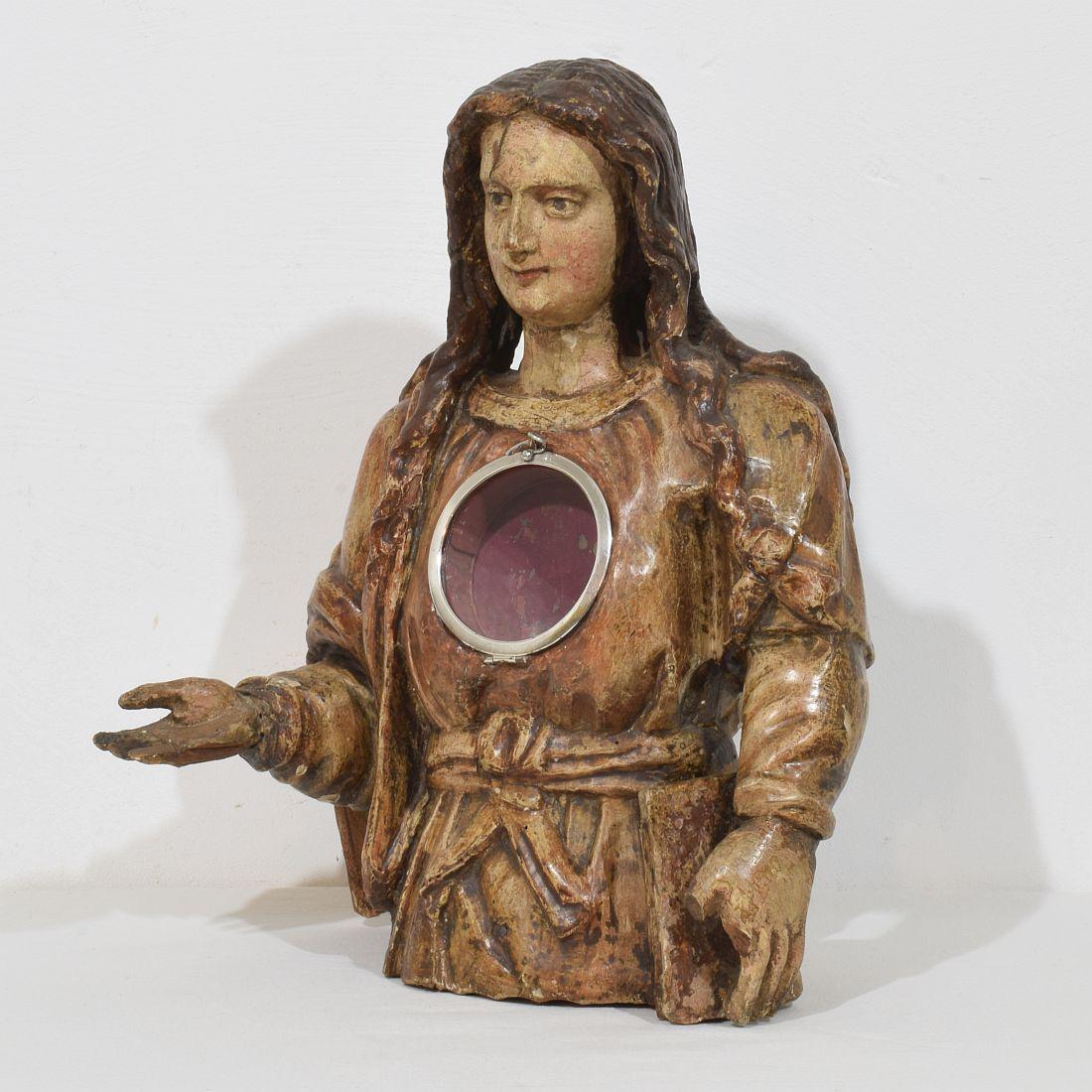 Pièce spectaculaire et très décorative. Grand buste reliquaire en bois sculpté représentant une Madone. De belles traces de couleur. Petites pertes et sans les reliques. La pièce centrale en argent/argent pour maintenir la relique est plus tardive,