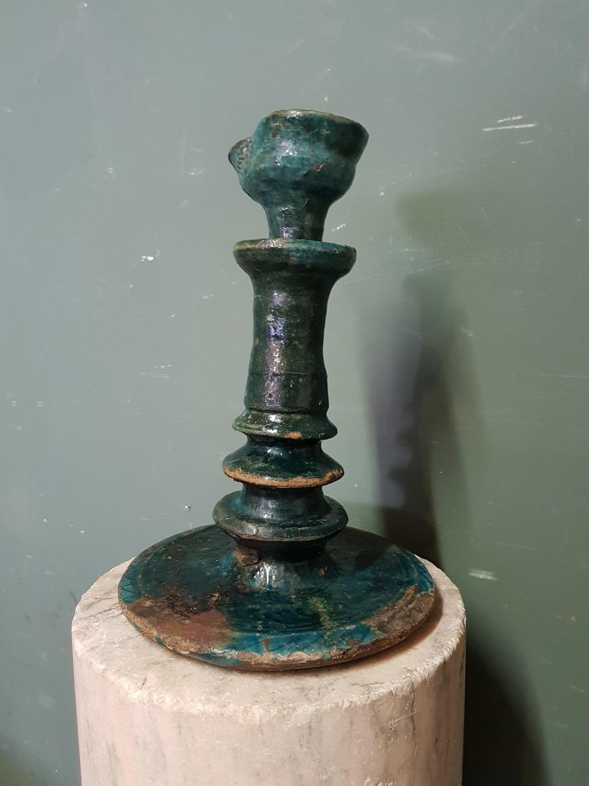 Antique Persian earthenware blue glazed standing oil lamp adorned with various motifs in the glaze, it has missing some glaze but no cracks and restorations. Originating from the 17th-18th centuries.

The measurements are,
Diameter 22 cm/ 8.6