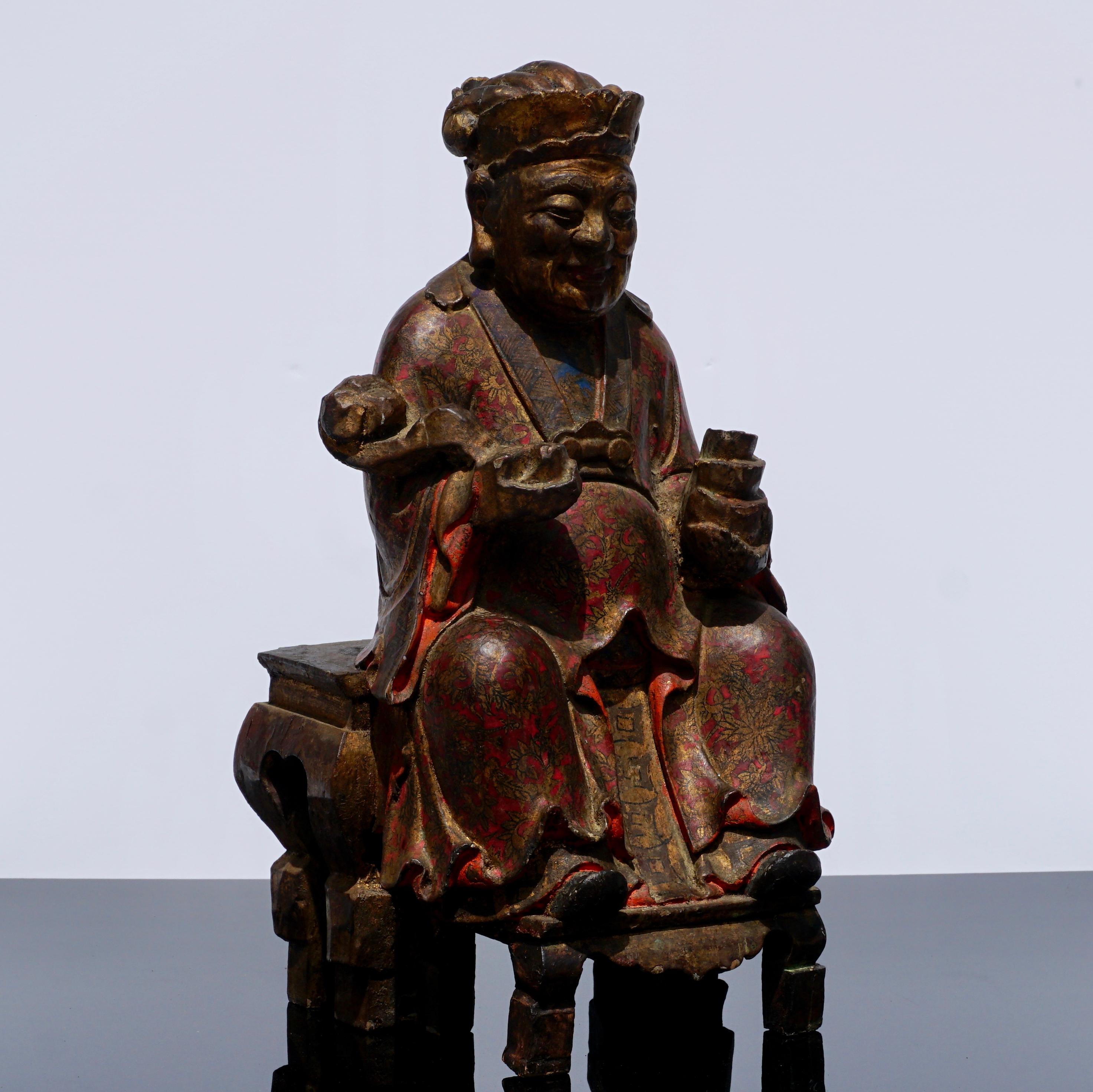 Early Qing dynasty carved polychromed wooden statue. Possibly a Chinese Emperor; This seated figure is intricately painted in cobalt blue and oxblood reds as only a Emperor’s robe and hat would be. The figure is holding a Rui scepter in his right