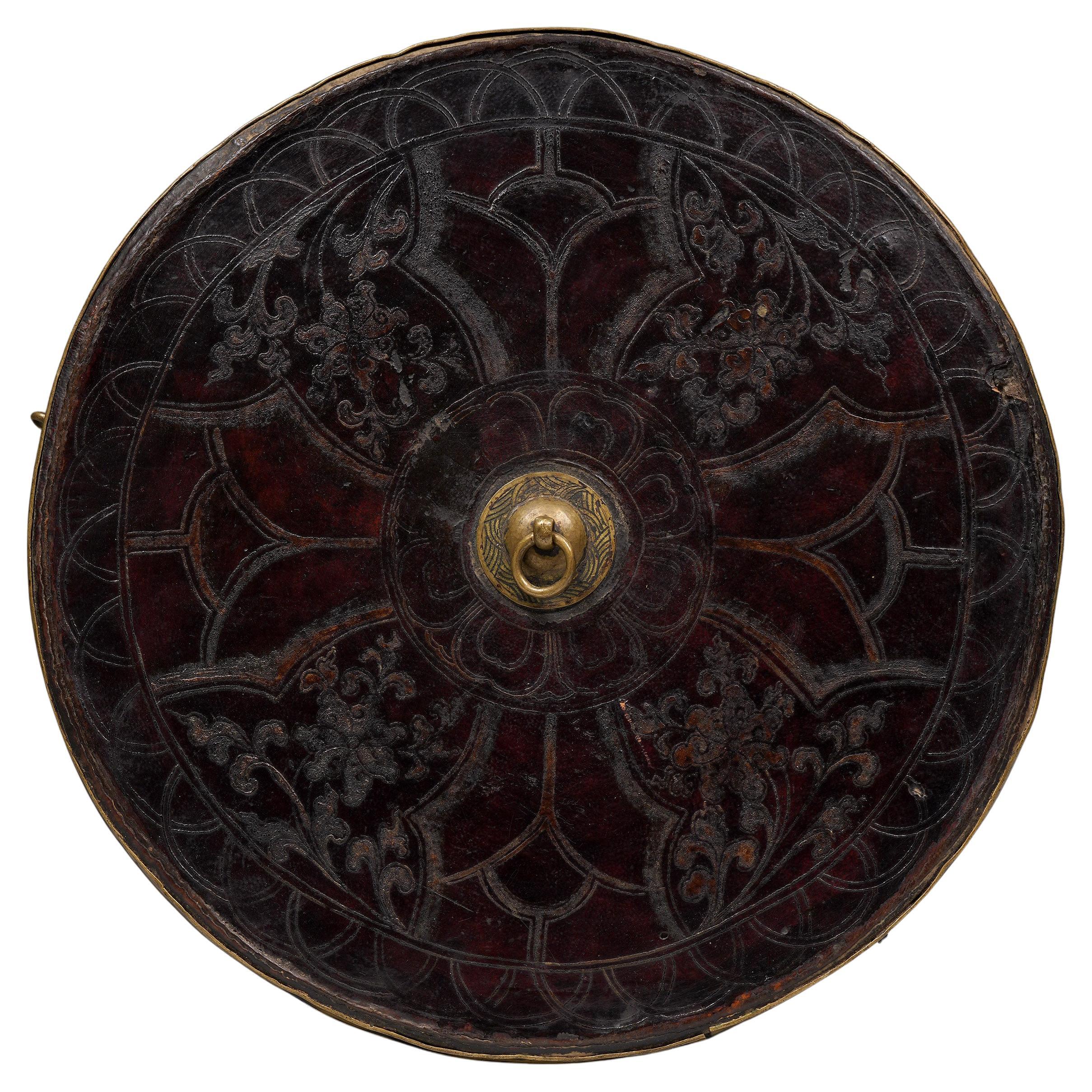 Boîte de rangement avec couvercle
Tibet
17e/18e siècle
Bois, cuir gaufré, laiton
H : 9.25 in x D : 12.5 in : : 24 cm x 31.75 cm

Un exceptionnel coffret rond en bois et cuir. Le plateau est orné de doubles motifs en forme de dôme et d'une tirette