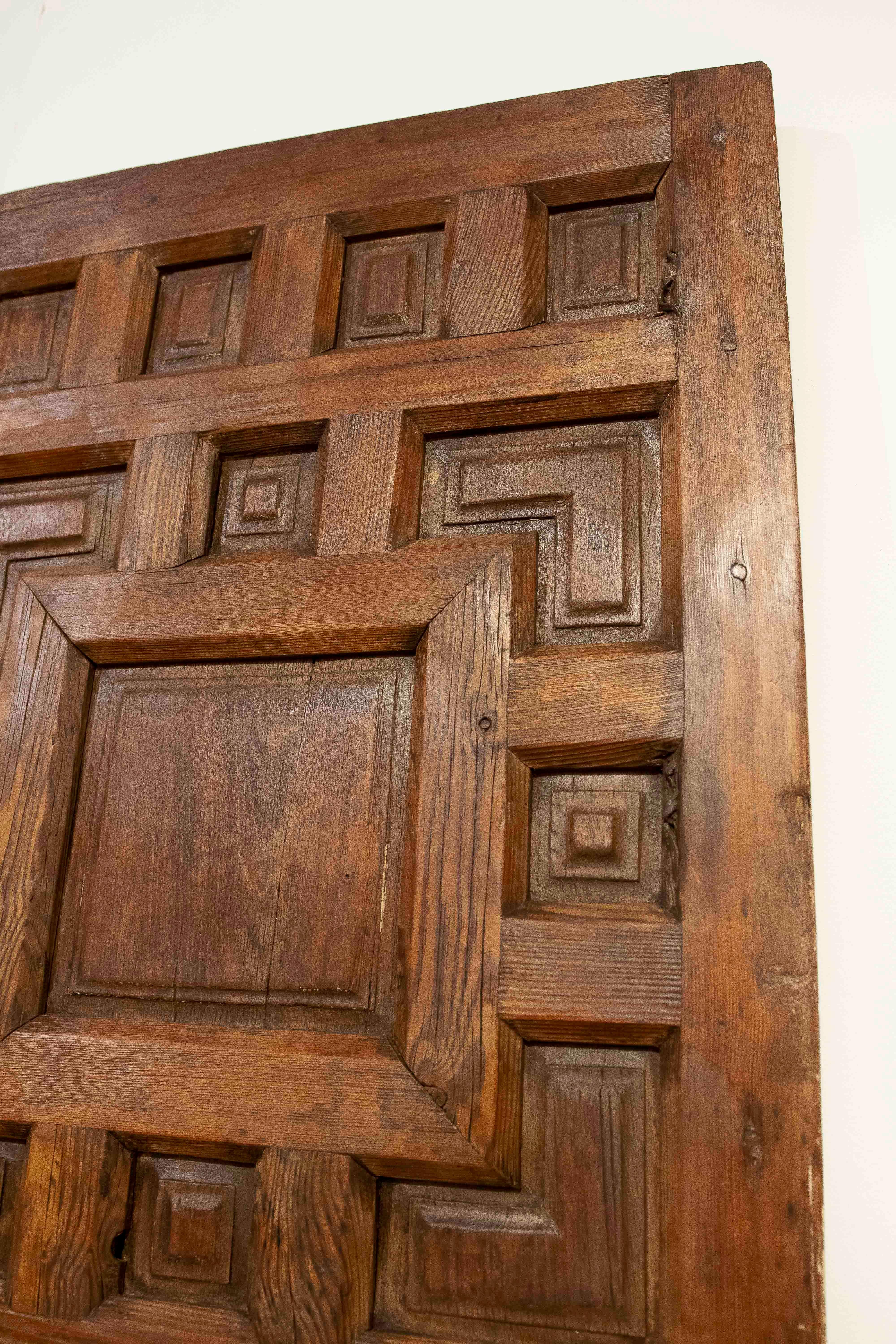 Solid wood double-leaf door with a geometric relief carving called 