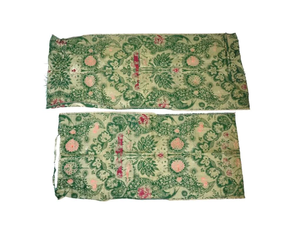 A lot of two antique hand woven embroidered textiles. The pieces are from the Persian Safavid dynasty period and are adorned with hand woven floral and foliage motifs, featuring primary gold and green hues, with subtle accents of red and pink. The