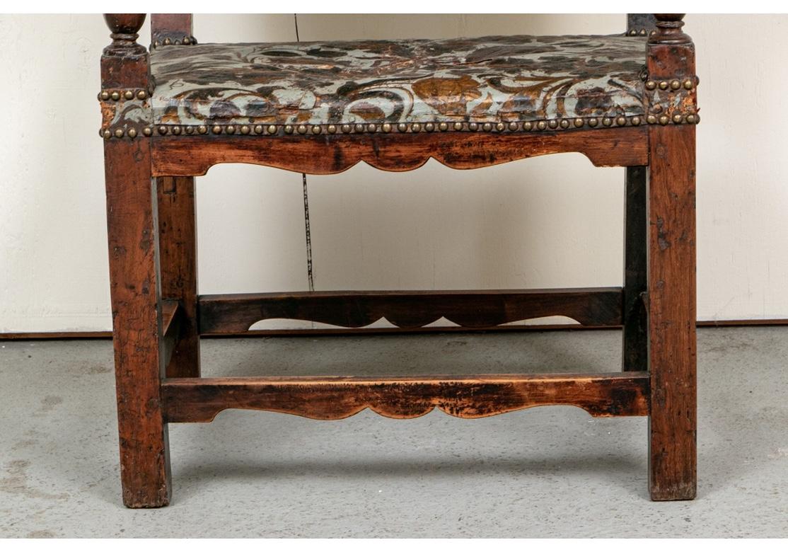 An extraordinary chair with superb color, large proportion and very good condition. The wood has a very soft hand and great marking. With polychrome leather embossed back and seat. The frame mounted with carved lion head mask finials on the top.