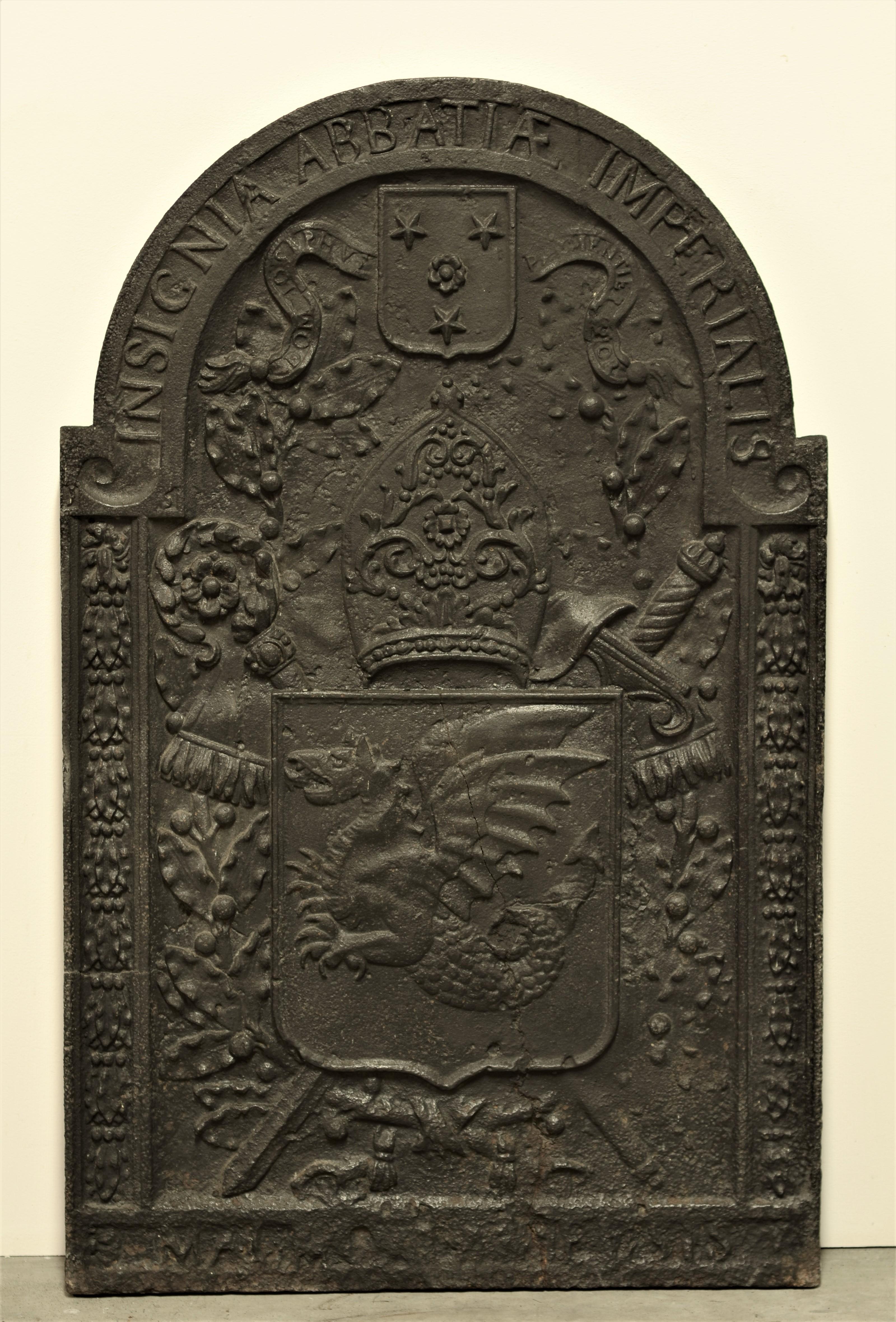 Unique 17th century cast iron fireback or backsplash.

This tall fireback is beautifully and strong decorated with a dragon on a shield with sword, between floral columns and below crested miter and shield.

Sign on top 