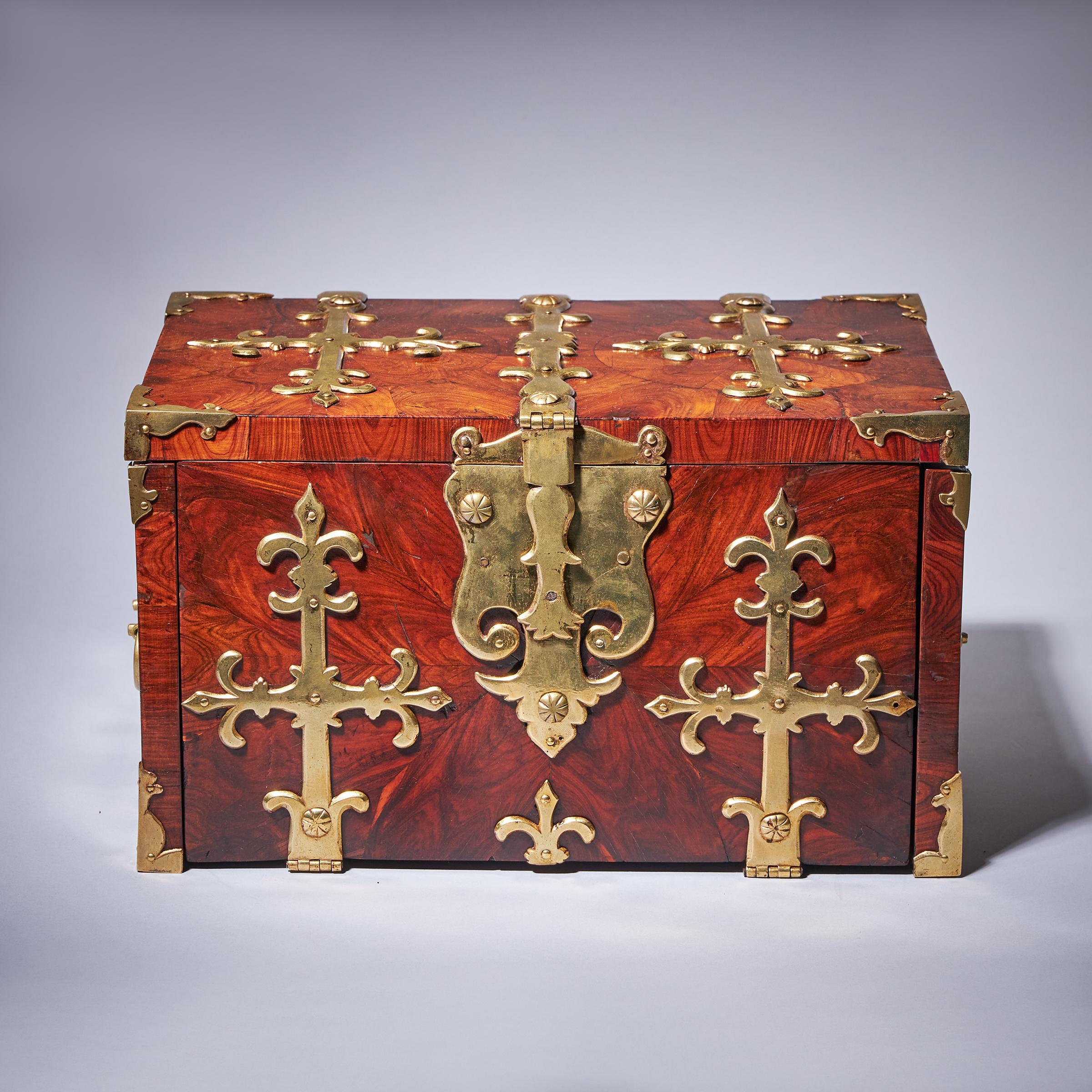 A William and Mary Kingwood/Princes oyster strongbox or Coffre Fort, circa 1680-1700, England. Adorned with highly decorative gilt brass strapwork and decorated entirely in knife cut oysters of kingwood, this box is fit for the most discerning of