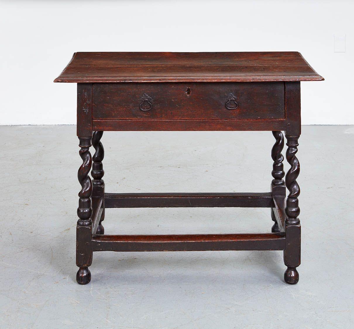 An early English oak table having two plank top with molded edge with overhang to all sides, over single drawer with center bronze pull, on corkscrew legs joined by rectangular section box stretcher. Wonderful proportions and very good color.