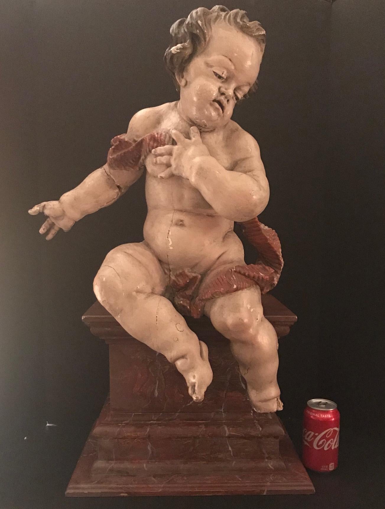 This exquisitely carved putto (#2 of 2) was originally part of a group on a high altar from an early Baroque church in Bavaria, Germany. Carved of limewood, it is expertly crafted with masterly attention to detail. Its face is characterized by