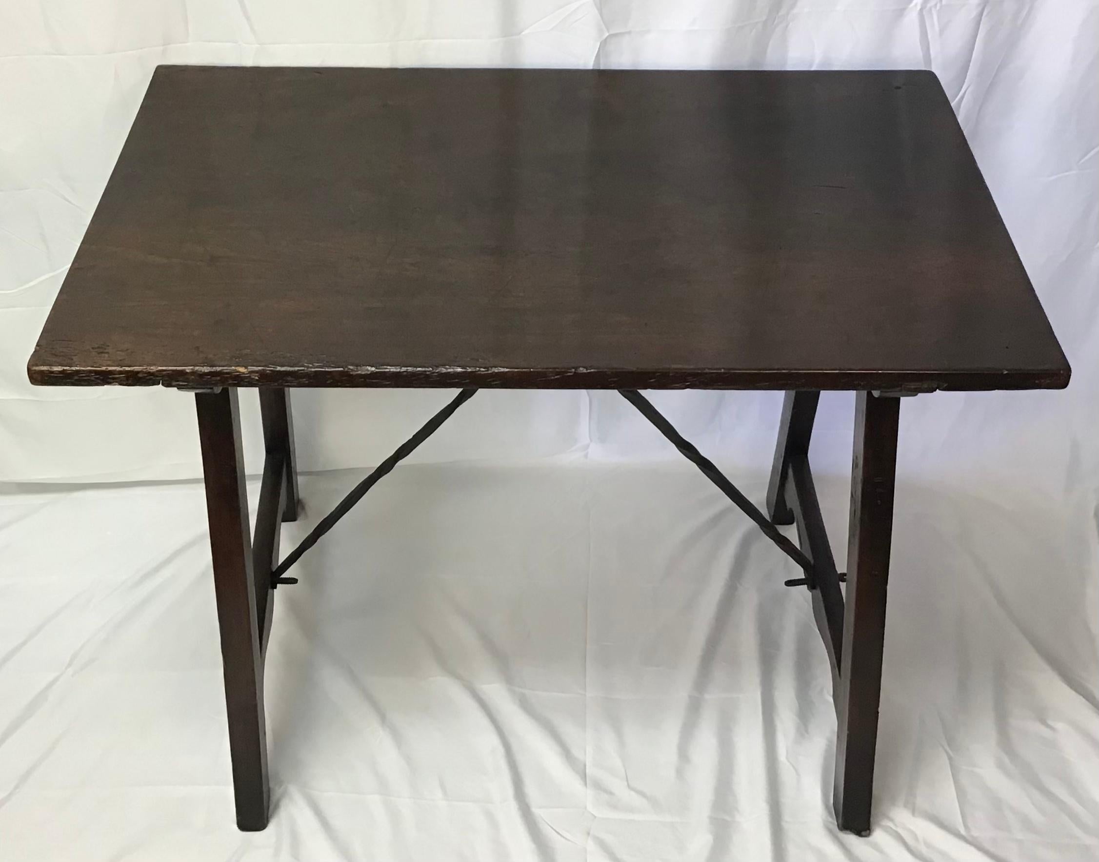 Italian, 17th century. Baroque walnut dining or tavern table having a shaped trestle base with iron supports. Perfect size to use as a writing table, sofa or center table.
