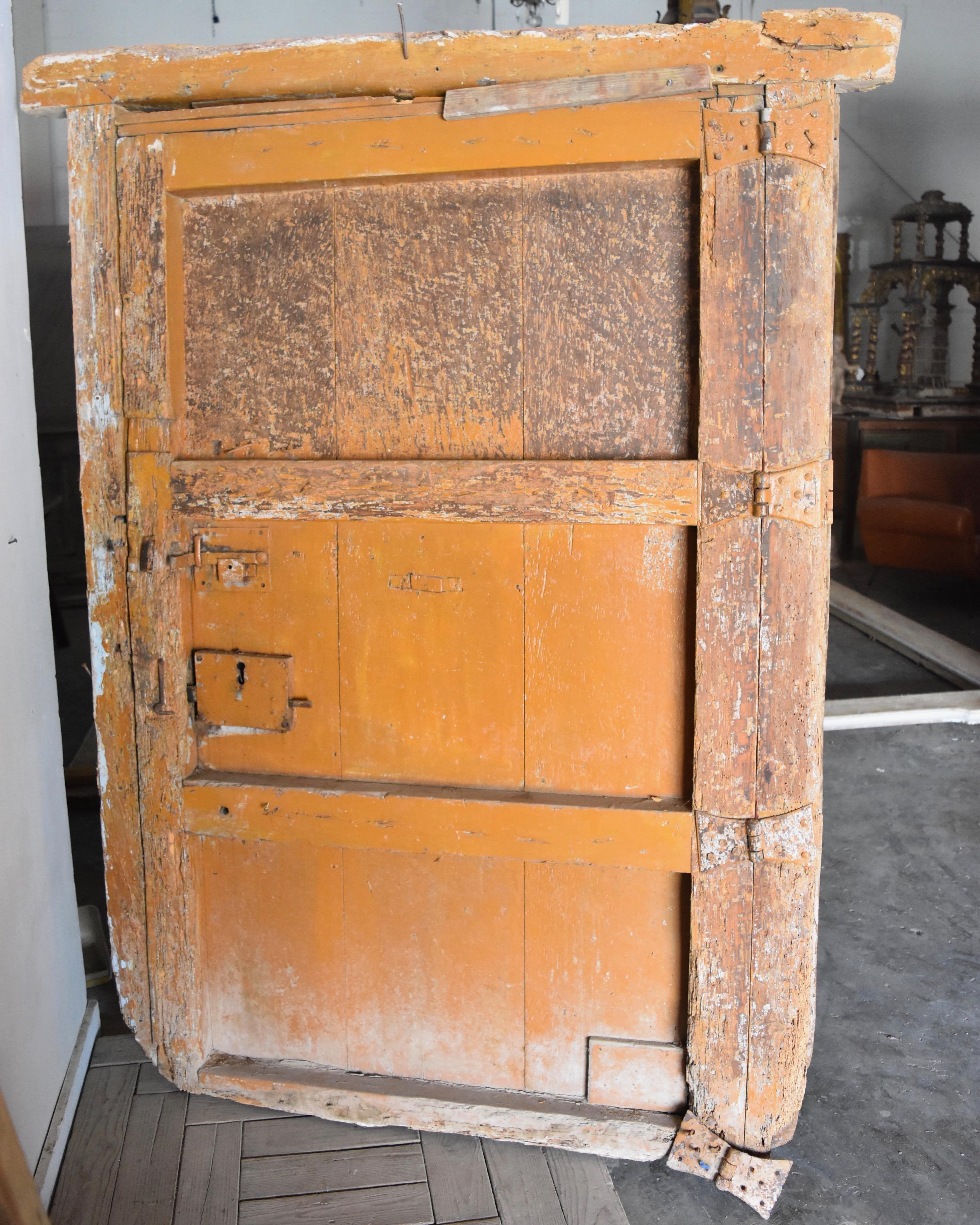 This is a thick heavy duty iron and wooden door from Spain. The paint is original. You can see the wonderful patina in the close up photos. It is distressed around the edges and really handsome in person. Lock and henges are still there as well.