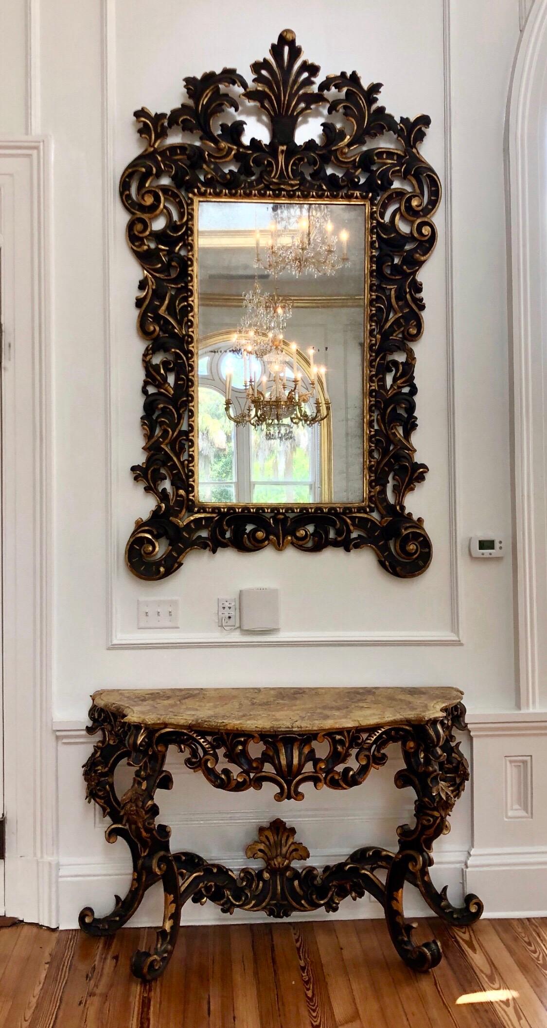Diese großartige venezianische Konsole mit Spiegel wurde im späten 17. Jahrhundert, etwa um 1680, in Venedig, Italien, hergestellt. Er hat eine polychrome und vergoldete Oberfläche mit einer handbemalten Kunstmarmorplatte über vier geschnitzten