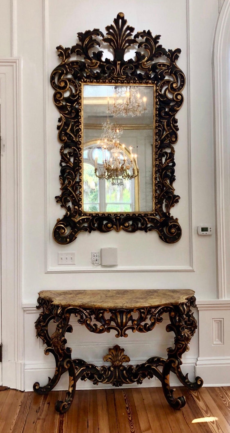 This Grand Venetian console and mirror was made in Venice, Italy, during the late 17th century, circa 1680. It features a polychrome and gilt finish with a hand painted faux marble top above four carved legs. The legs are each carved as abstracted