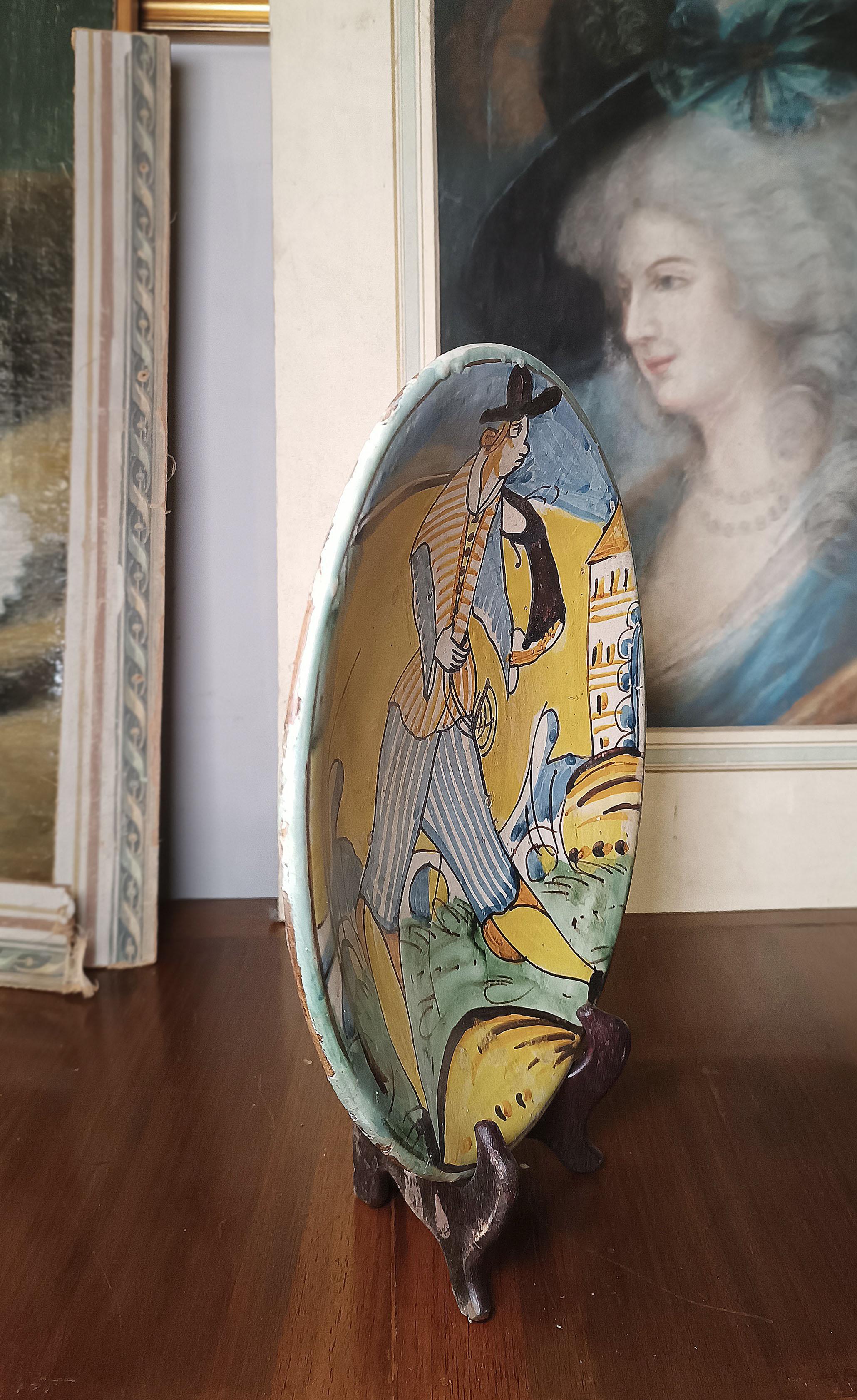 Splendid polychrome majolica plate belonging to the Montelupo ceramic workshop. The enamel has also been applied to the rim, in an elegant aqua green, while the background is white decorated with brown lines that further enhance its beauty. The body