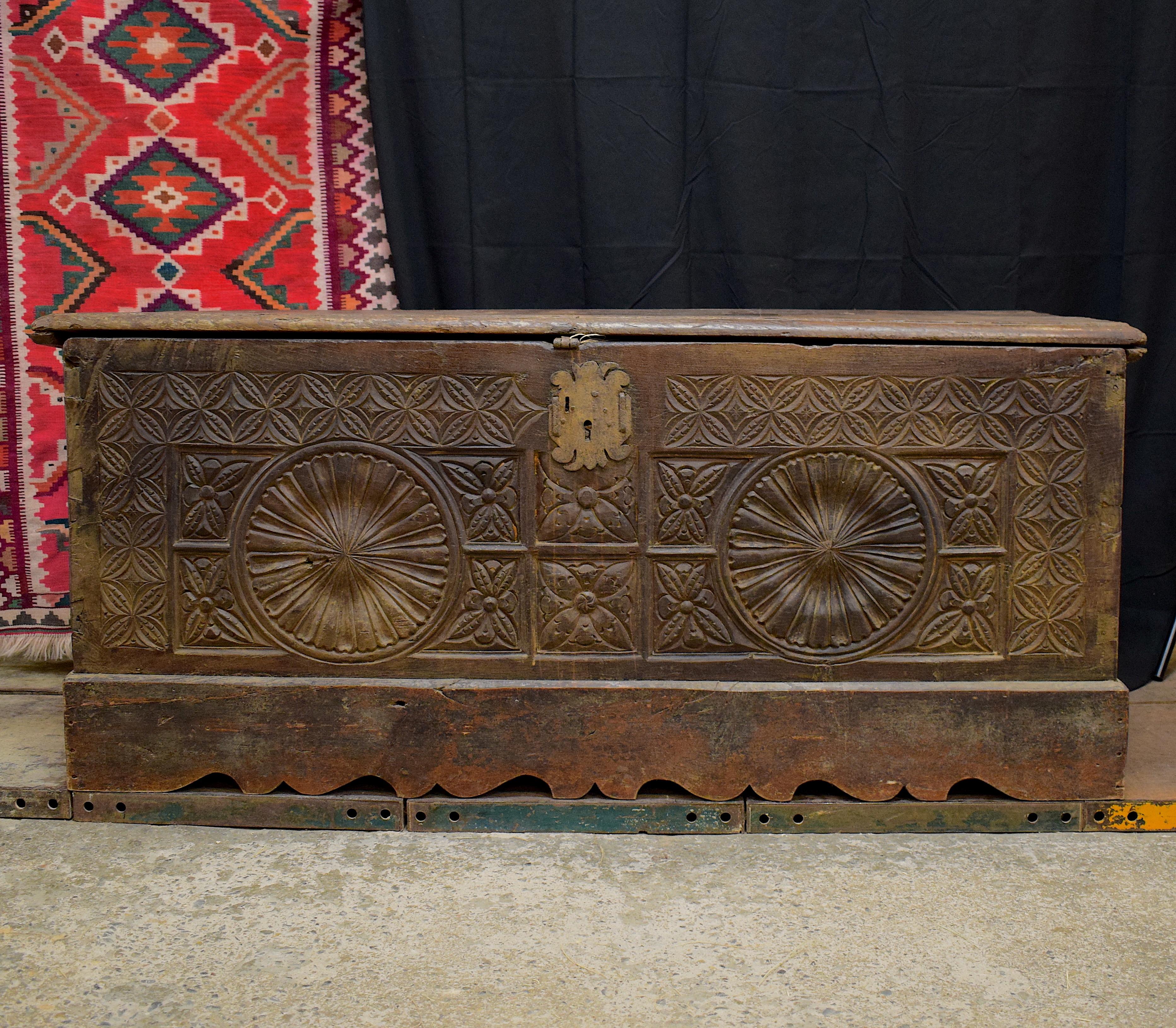 A French 17th century large carved oak trunk. This trunk features a long rectangular shape body whereby the front panel has carved into it a Gothic style ornamentation in the form of a geometrical design. The top, sides and back have no carved