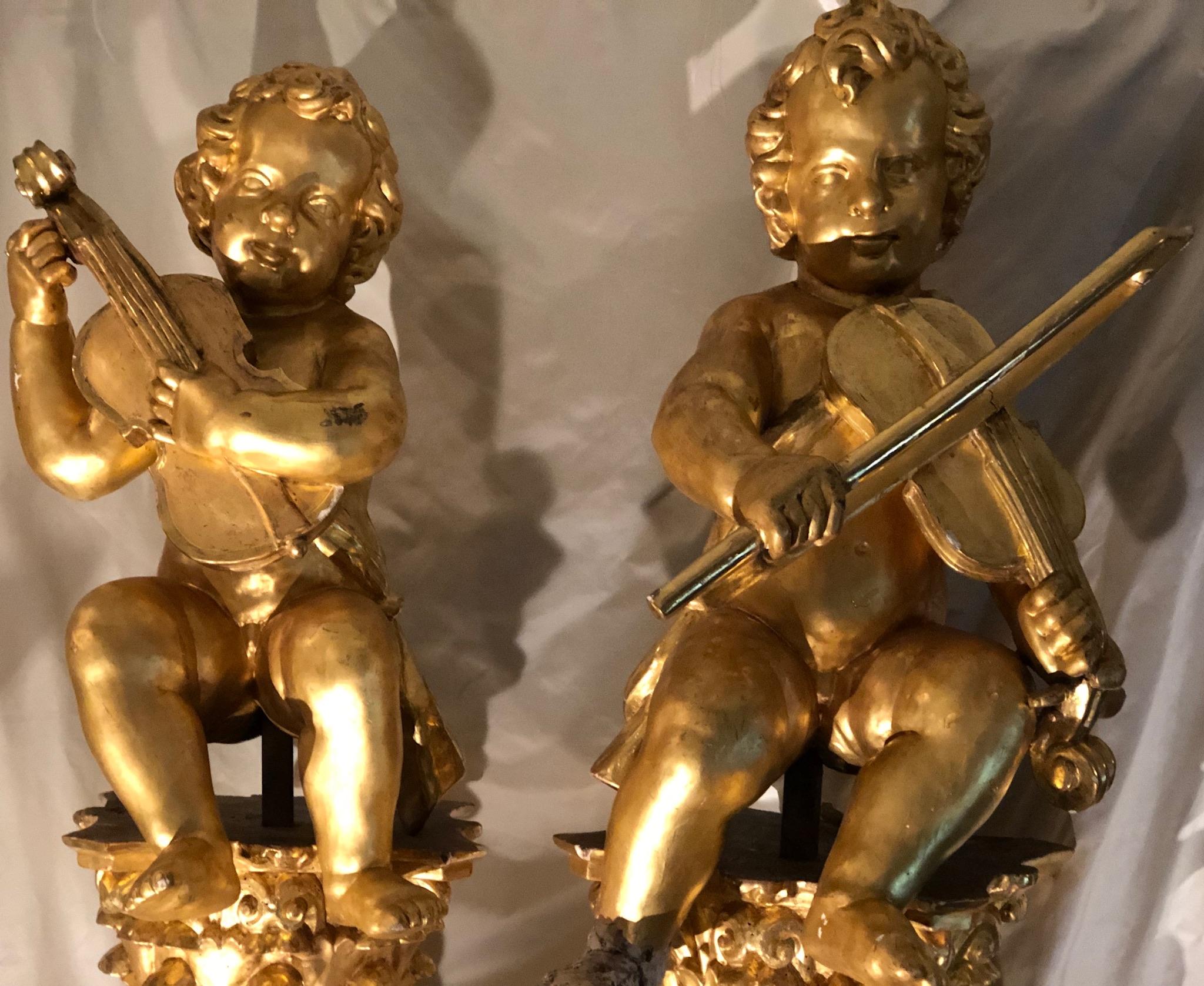 Pair of antique Solomonic columns crowned by Corinthian capitals on which musical Puttis, or Angels are perched.
This pair of columns, have those unique visable signs of age (wormholes, see pics ) despite having been re gold leafed (re-gilt) in the