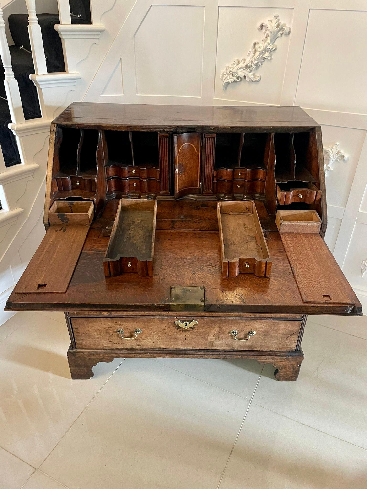 17th century antique quality oak bureau boasting an outstanding interior and having a quality oak fall with a reading slope opening to reveal an incredible serpentine shaped interior consisting of eight serpentine shaped drawers, four secret