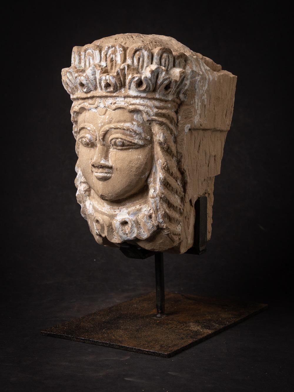 La tête antique en grès de l'Inde est un artefact remarquable et historiquement significatif, aux racines culturelles et artistiques profondes. Fabriquée en grès, cette tête mesure 42 cm de hauteur, 20,5 cm de largeur et 32 cm de profondeur, socle