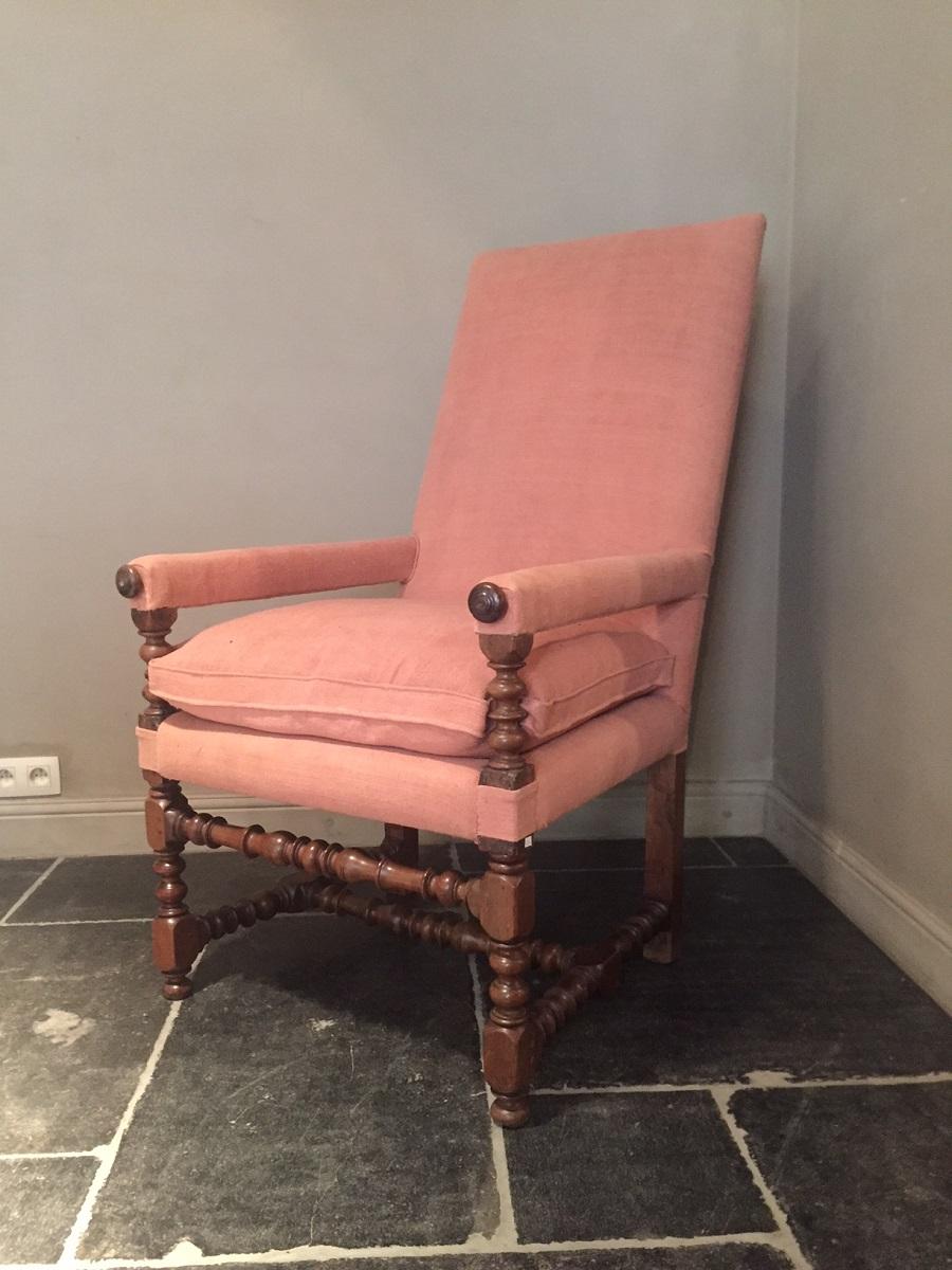 Fine French Louis XIII armchair. Made in the 17th century from walnut and equipped with hidden out sliding tray supports as a extra feature. We restored this armchair and reupholstered it in a 19th century crimson linen. All visible wood is still
