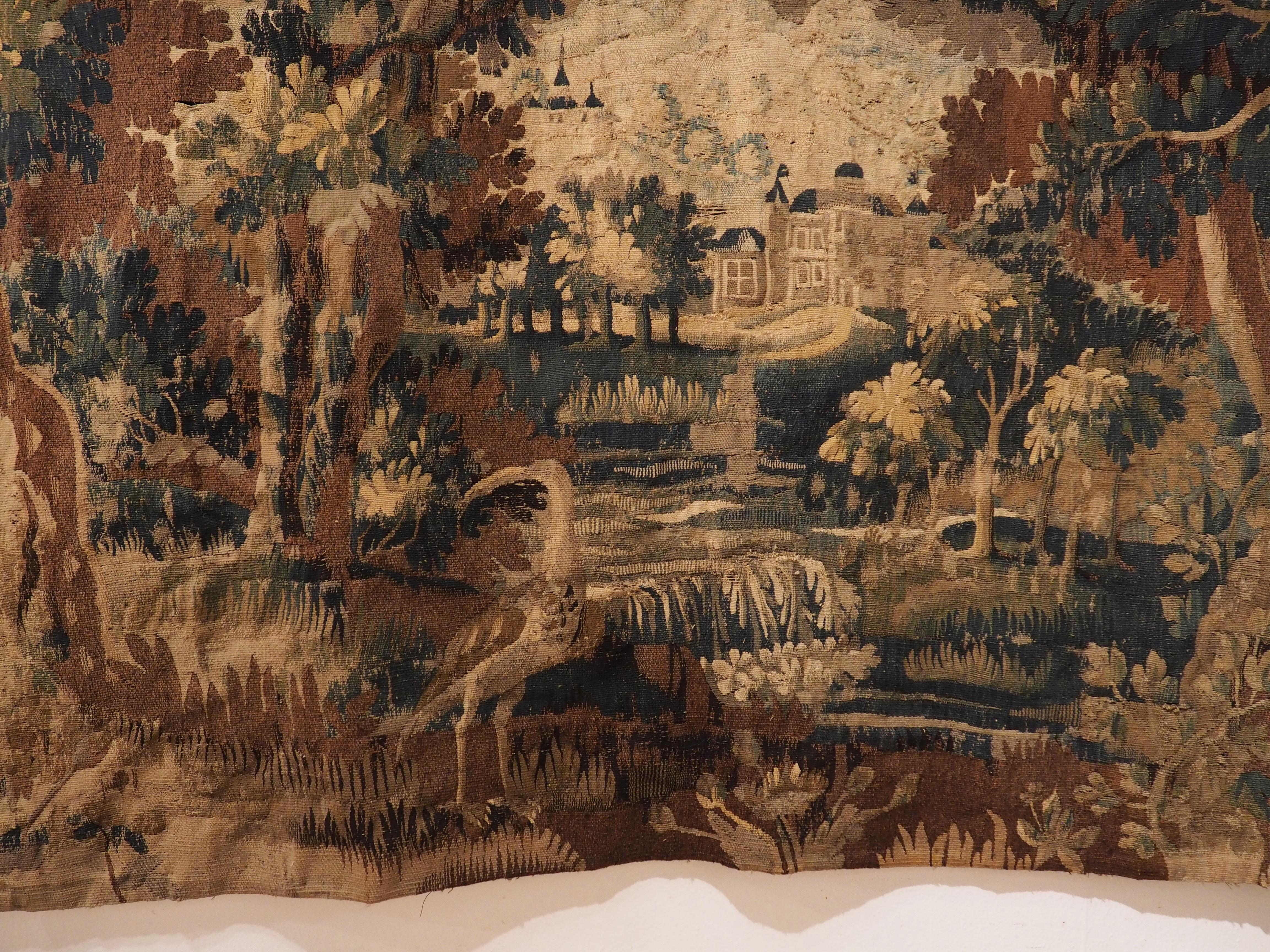 During the 18th century, tapestries manufactured at Aubusson were considered among the finest wall-hangings in France, along with creations from Gobelins and Beauvais. This verdure tapestry featuring a heavily wooded chateau scene was an earlier