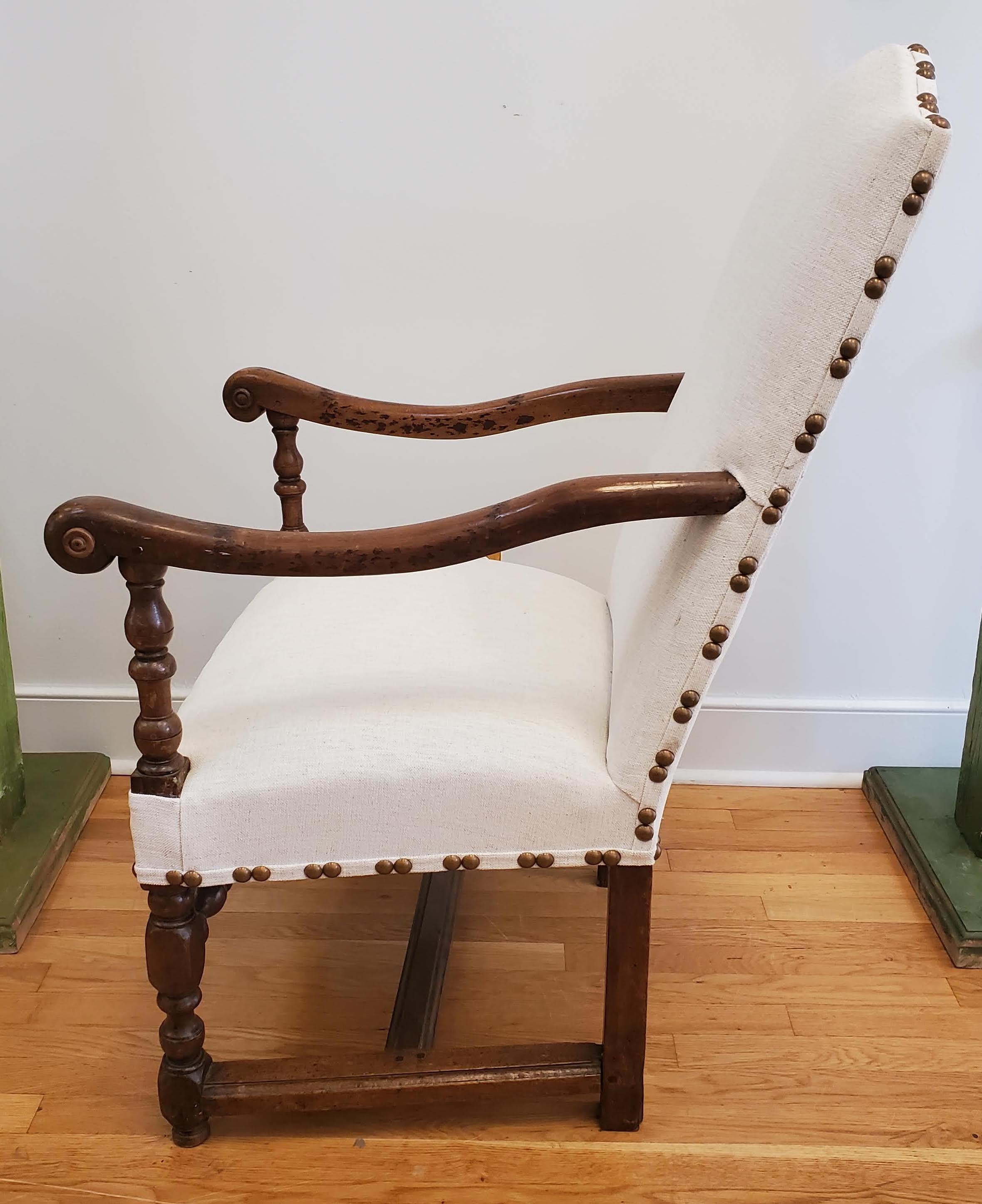 17th century Baroque French Provincial walnut armchair with modern upholstery arched back with sweeping arms with turned legs and stretchers. Made of deeply patinated walnut with a lustrous color. Remarkably comfortable. Recently reupholstered in